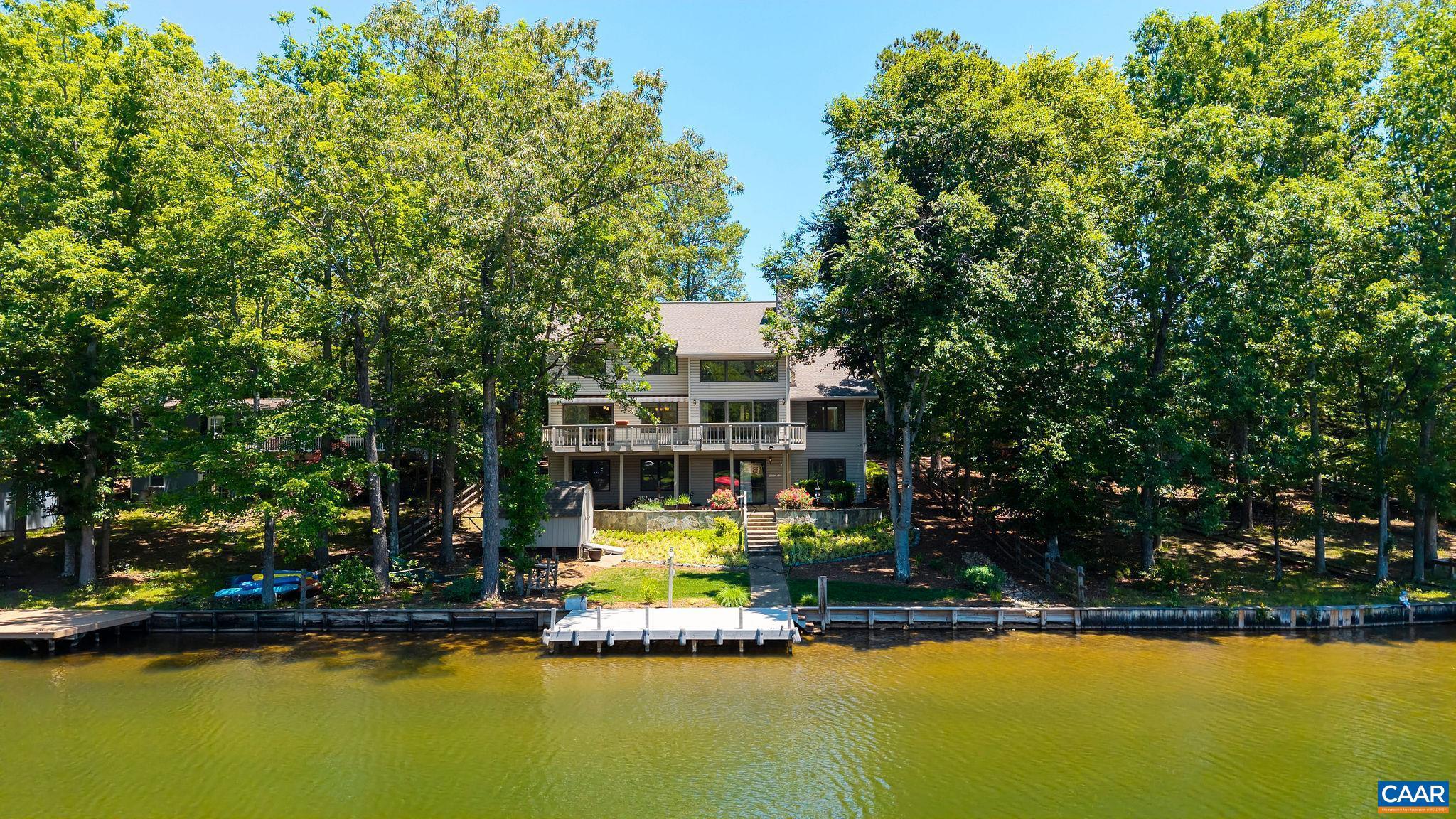 Pristine 5 bed, 3.5 bath waterfront home at Lake Monticello with a magical setting & beautiful lake views!!! Adjacent to lake amenities - main beach, tennis, pickleball, basketball, pool, playground & clubhouse. Enjoy easy access from your backyard to the water?s edge. Surrounded by native gardens maintained thru Thomas Jefferson Soil & Water Conservation & expert hardscaping by Armstrong Landscape. Expansive decks (with awning) span the entire length of the home, perfect for relaxing. From the dock Celebrate with Golf Course 4th of July fireworks. Inside, soaring ceilings, a wall of windows with tinted 2nd-story glass & a stunning floor-to-ceiling stone fireplace all create a bright, inviting space with cozy lake views. The foyer welcomes you with warm wood trim, hardwood flooring thru-out, tastefully updated kitchen/baths for move-in readiness w/gorgeous cabinetry, stone counters & 2x6 construction. Terrace level offers in-law suite potential, cozy woodburning stove, 2 bedrooms, full bath, & a cozy living area with wood-burning stove & backyard access. Updates include: roof (2018), HVAC (2019/21), water heater (2022), shades (2023), seawall (2023), dock (2024), plumbing (2016), plus storage room & garage ramp for accessibility.,Granite Counter,Wood Cabinets,Fireplace in Family Room,Fireplace in Living Room