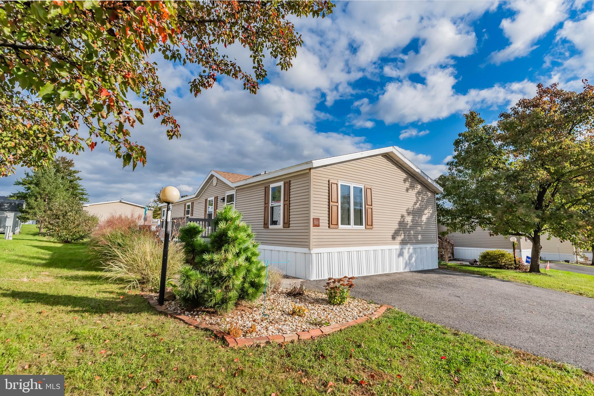 Welcome to this charming double-wide mobile home that perfectly blends comfort and style. Featuring three bedrooms and one and a half baths, the home features vaulted ceilings throughout, enhancing its spacious feel. Enjoy newer luxury vinyl plank flooring that flows seamlessly through the  living room and updated kitchen, which includes a double sink, electric range, stainless steel appliances, and a skylight that floods the space with natural light. The primary bedroom offers a private retreat with its own full bath, also illuminated by a skylight. Step outside to a deck overlooking the rear yard, ideal for entertaining or relaxing, and take advantage of the convenient storage shed. With beautiful mountain views.