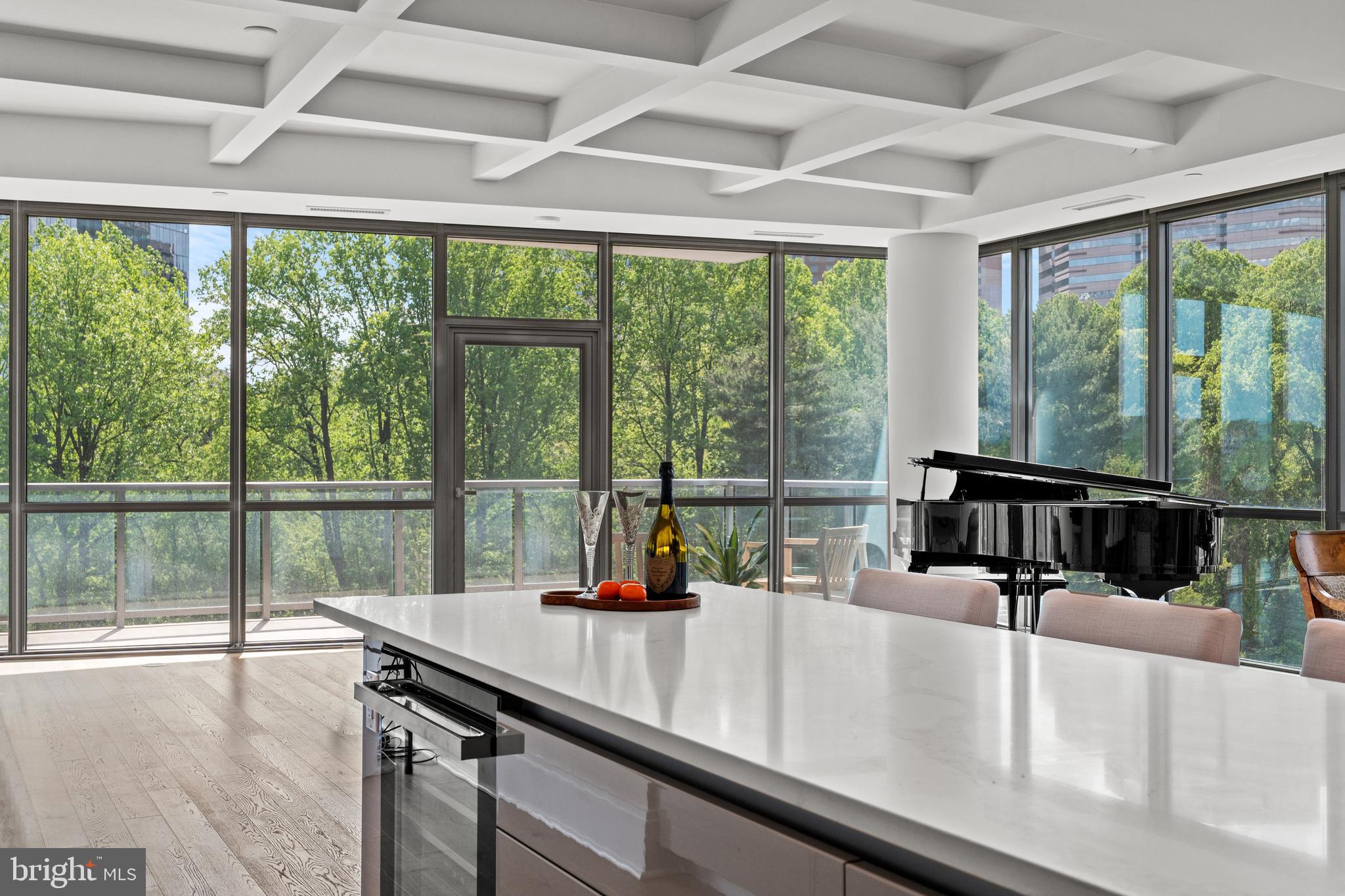 Presenting one of the first re-sale opportunities at the Monarch, this remarkable 2-bedroom, 2.5-bathroom  + den model condominium offers a lifestyle of unparalleled luxury. Begin your journey with private elevator access, whisking you away to a space adorned with breathtaking views from every window. Immerse yourself in the lush greenery, expansive park views, and a serene abundance of trees that surround this exceptional home.
The den has been thoughtfully removed to expand the living space, allowing natural light to flood in through walls of windows, creating a bright and inviting atmosphere. The open, chef-inspired kitchen is a masterpiece, featuring top-of-the-line Miele appliances, Italian cabinetry, quartz countertops, and an oversized island perfect for entertaining.
Experience the elegance of distinctive Khars white oak flooring throughout. The primary suite is a haven of tranquility, boasting floor-to-ceiling windows with private, picturesque views. Indulge in the luxurious primary bath, complete with a lavish soaking tub, oversized shower, exquisite finishes, and fixtures. A separate water closet and walls of hidden cabinetry add to the opulence.
The second bedroom is equally spacious, offering a walk-in closet and a customized bathroom with an oversized shower. This residence also includes the convenience of a laundry room complete with front load washer, dryer and  custom cabinetry .   There are two underground parking spaces and a storage unit.
Embrace the “lock and leave” lifestyle at the Monarch, where 24-hour concierge service is dedicated to anticipating your needs. A plethora of amenities awaits, including a full gym, tranquil pool, social lounge, rooftop social/private dining room, outdoor grilling/bar area for entertaining, and a hospitality suite for visiting family or overnight guests. All of this, combined with the convenience of being in the heart of Tysons, makes this home truly spectacular.