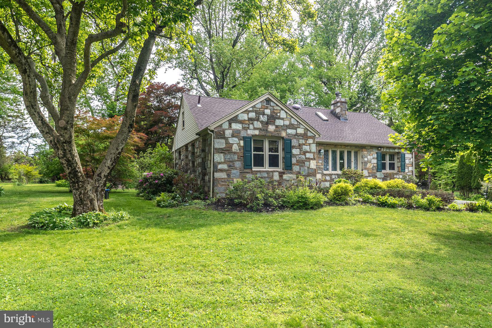 Classical and charming, stone beauty!  Be impressed when you step through the threshold of this home with many period and quality features from the mid 20th century including: a stone fireplace, recessed wall alcoves, cast iron radiators, archways, hardwood floors and more.  Balancing traditional features with modern amenities, the updated kitchen features brand new granite countertops,  with sleek black and stainless appliances. Just off the kitchen is a massive, light-filled dining room with chair rail, and crown molding.  The cozy and character filled living room features a large bay window, recessed lighting,  fireplace, and multiple alcoves.  A den with vaulted, tongue and groove ceiling overlooks the verdant back yard.  Two bedrooms, and an updated full bath round out the first floor. The second floor has 2 additional bedroom, a full bath, and a loft/library area that  is currently used for crafts but could also be used as a library, play room, gaming room, music room. The possibilities are endless for this space. Transition easily to the outdoor space via the large deck which overlooks the huge and lush back yard. The yard is a gardener's delight dotted with beautiful perennials, and shade trees, and features a fire pit and patio. This classical beauty is conveniently located just steps to major commuter routes, shopping, dining, and parks and recreational facilities.  The flexible layout offers both first and second floor bedroom and bathroom spaces which can meet a multitude of needs. New roof installed in 2025. One year home warranty included