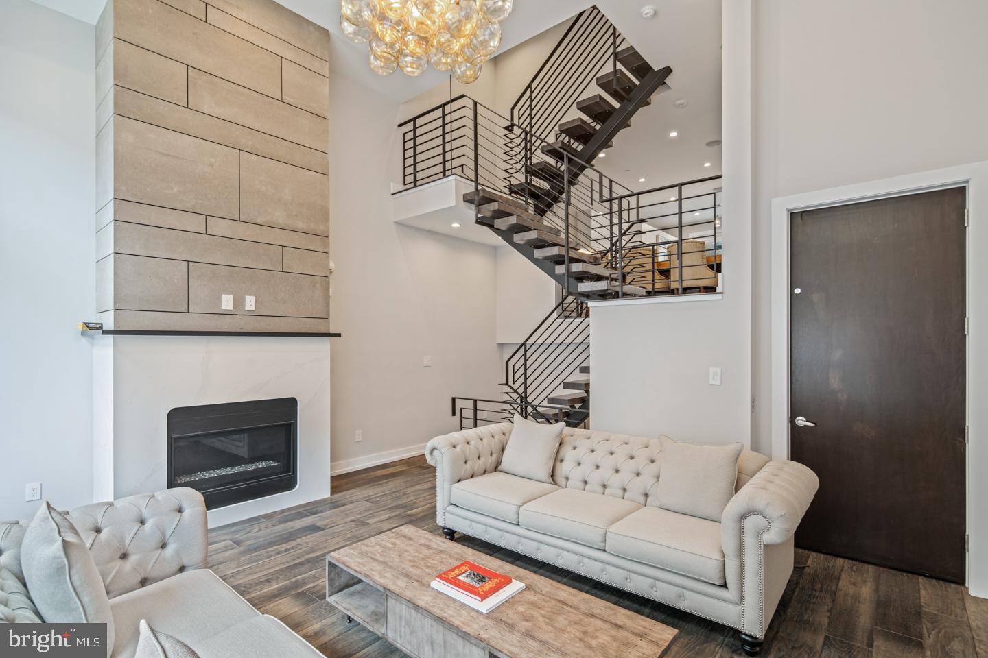 Presenting 1333 Bainbridge St, a stunning 5 bed, 3.5 bath home located in the private gated Kater Court community. Highlights of this 2 year old, like-new home include five private outdoor spaces- two roof decks & three balconies, 2-Car garage parking, a 7-stop elevator, over 4,200 square feet of living space, and 8.5 years of Tax Abatement remaining. Enter into the main sitting room featuring wide-plank hardwood floors that continue throughout the home and a stunning fireplace spanning from the floor to the 16' ceilings. Continue up to the open concept kitchen and dining room where you'll find top of the line Sub Zero and Wolf appliances, custom European cabinets, an oversized waterfall island, under cabinet lighting, and access to the first of five outdoor spaces. Up the floating stairs with 3-inch oak treads you'll find two spacious bedrooms each with walk-in closets and one with a private balcony. A tasteful hall bath with dual vanities and convenient upper-floor laundry complete the second level. The third floor Owner's Suite boasts a tranquil master bath, private Juliet balcony, and a fourth bedroom that has been converted into an enormous walk-in Wardrobe closet. An additional full bath on this level is convenient to the roof decks and fourth floor living space. This flex space offers the perfect place for entertaining, a home office, or sun-filled yoga studio. Take the elevator back down to the lower level where you'll find a fully finished basement with 12' ceilings, a second fireplace, and a separate den. Additional features of this incredible home include 8.5 foot solid core doors throughout, surround sound built-in on all levels, dual-zone Nest thermostats, and a Ring doorbell. Right in the heart of Center City, this property is located steps from South Street and within walking distance of Rittenhouse Square, Queen Village, and all of your favorite hot spots in the city. Make an appointment today because this home is sure to wow you!