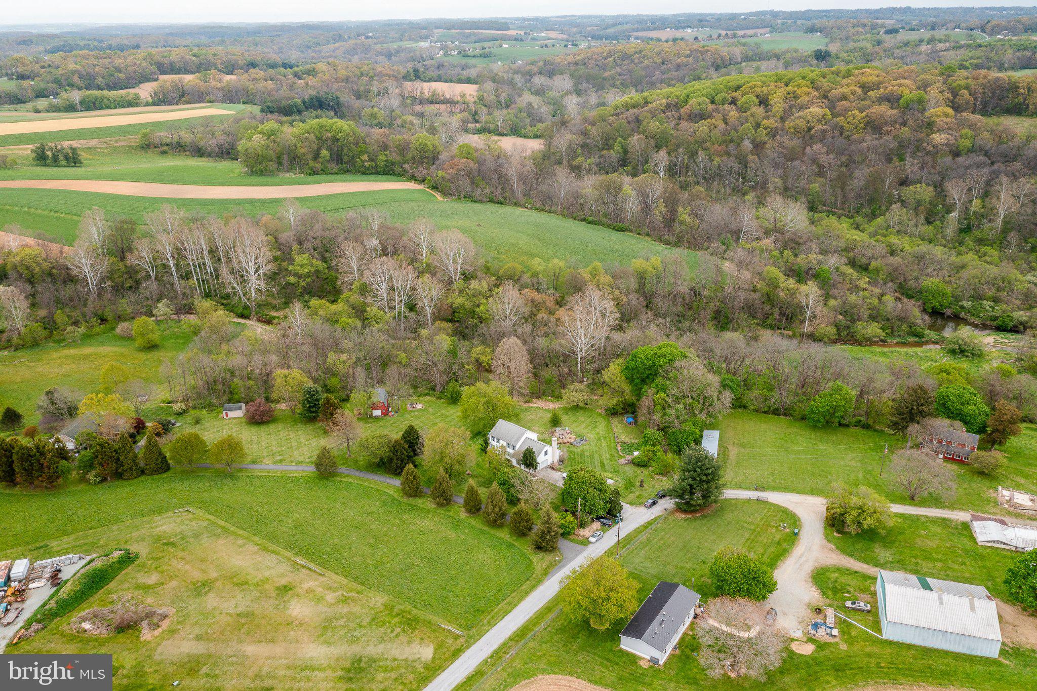 A true retreat for nature lovers, 45 Latham Road offers a rare blend of privacy, charm, and natural beauty. Nestled on 15 serene, wooded acres, this unique property sits at the meeting point of the McCreary Run Stream and Octoraro Creek, boasting approximately 900 feet of private water frontage and abundant wildlife in every direction.

The home exudes a warm, Colonial-inspired character and has been thoughtfully updated throughout. Inside, you’ll find a welcoming foyer flanked by a bedroom and an open-concept living and dining area connected by elegant French doors. The main living spaces flow effortlessly, highlighted by a floor-to-ceiling brick fireplace, expansive windows, and inviting gathering areas.

The updated kitchen is both stylish and functional, featuring granite countertops, stainless steel appliances, recessed lighting, a center island, and an adjacent dining area with direct access to the deck—perfect for outdoor meals and entertaining. A bright family room with custom built-ins and scenic views completes the heart of the home. The first floor also includes a full bathroom and a convenient laundry room with additional storage.

Upstairs, you’ll find four spacious bedrooms and two full baths, including a comfortable primary suite with its own en-suite bath. The walk-out lower level offers endless possibilities—ideal for a recreation room, home gym, or additional living space—opening directly to the expansive outdoor setting.

Outdoor living is just as impressive, with a screened porch, elevated deck, and patio with firepit, all designed to take full advantage of the peaceful surroundings. As the last home on the road, the property ensures exceptional privacy and is bordered by preserved land, including the nearby Oxford Foundation preserve.

Wildlife enthusiasts will appreciate the frequent sightings of bald eagles, deer, foxes, beavers, and wild turkey. Whether you enjoy hiking, birdwatching, fishing, or kayaking right from your backyard, this property offers a lifestyle immersed in nature.

Despite its secluded feel, the home remains conveniently located within reach of major travel hubs and regional destinations, making it an ideal balance of escape and accessibility.