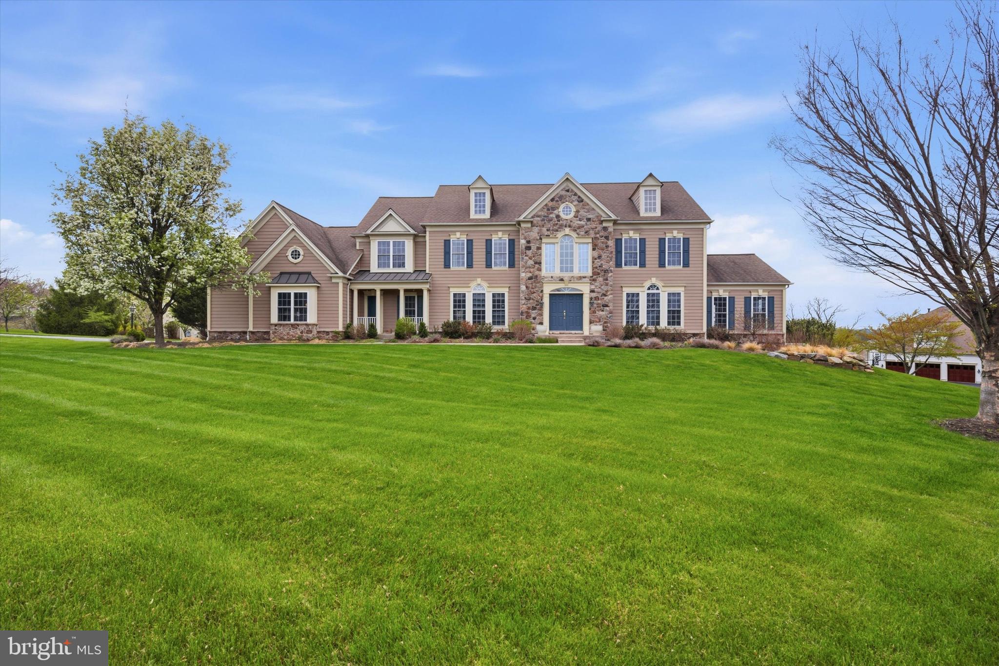 Welcome to 8 Deerfield Drive, a stately stone & HardiePlank Colonial style home nestled on a one-acre corner lot in the award-winning Great Valley School District. The tasteful St. Regis model is the largest floor plan in the Deerfield Community, offering over 5100 square feet of comfortable living space with thoughtful details throughout. Step into the 2-story foyer featuring hardwood floors, wainscotting, and a curved staircase with an open 2nd floor landing overlooking the family room below. To the left is the spacious dining room with detailed tray ceiling and wainscotting that creates an elegant space to host dinner parties for family & friends. To the right is the formal living room with crown molding, recessed lighting and French doors leading to the oversized sunroom with Palladian windows; a light filled, multi-purpose space with doors leading to a private balcony. Continue to the office, another flexible living space that would also be perfect as a den or playroom. The two-story great room is the heart of this home featuring a wood-burning fireplace, floor to ceiling windows, and offering plenty of space to gather. The gourmet eat- in kitchen is highlighted by an abundance of raised panel cherry cabinetry, granite countertops, a large center island with prep sink & seating, stainless steel appliances, built-in desk, and a large walk-in pantry. Enjoy casual meals in the adjoining breakfast room with French doors leading to the maintenance-free Timbertech deck; a perfect place to dine al fresco and entertain in the warmer months. Completing the first floor is the powder room with separate water closet, as well as the laundry room with plenty of cabinets and a convenient sink. Head upstairs to the impressive primary suite featuring a sitting room and spacious primary bath with vaulted ceiling, twin vanities, soaking tub, glass-door shower, and massive walk-in closet. Three additional bedrooms, each with their own full-bath, complete the second level. The basement houses the utilities, including the whole house generator, and provides plenty of storage space. This walk-out level with an abundance of natural light and access to the patio provides the opportunity for additional living space and/or entertainment areas. Amazing location, close to Malvern Borough and King of Prussia shopping & dining and just minutes to Rt 202 and the PA Turnpike, making commuting a breeze! You don’t want to miss the opportunity to call this gorgeous house, HOME. Schedule your private tour today!