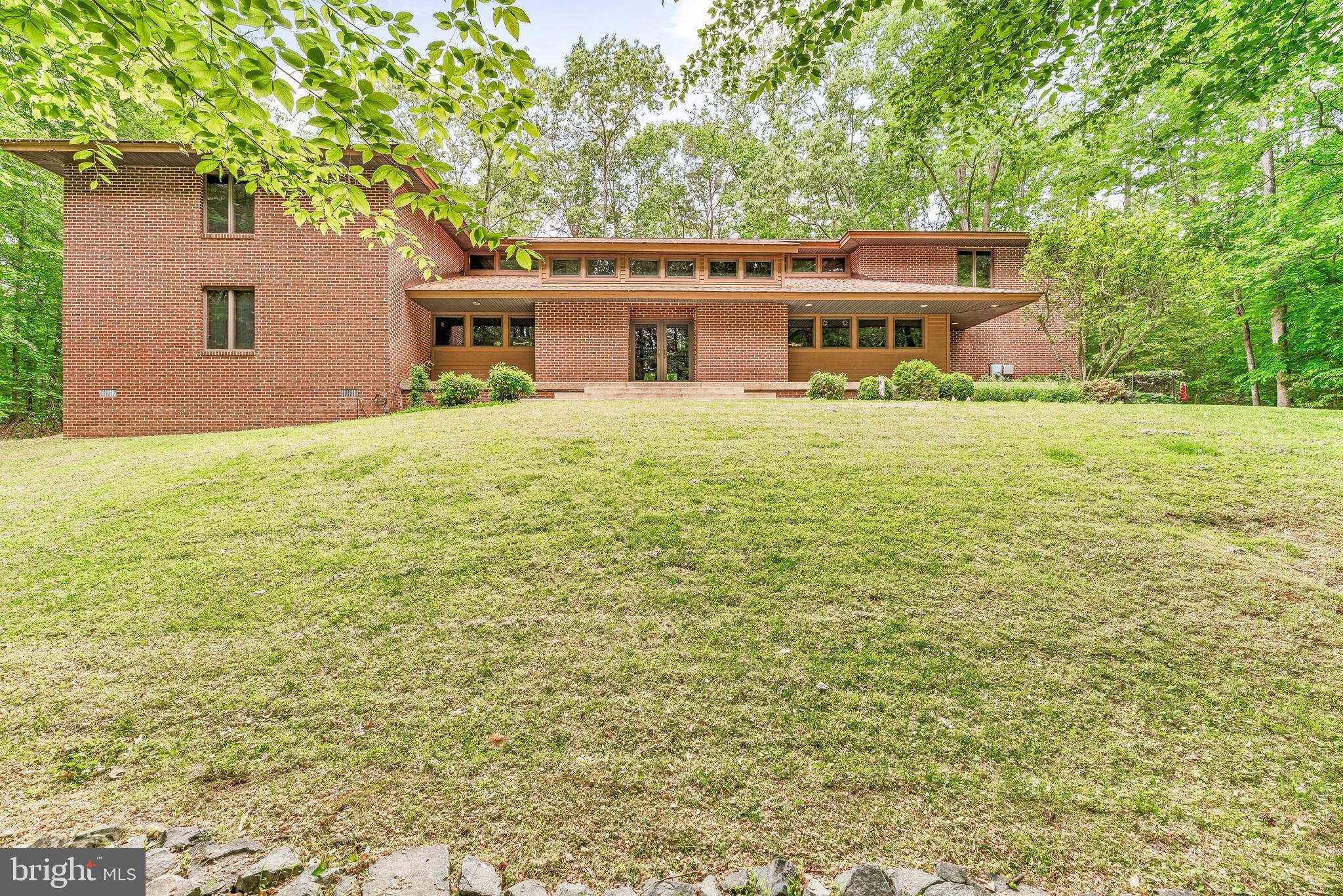 PRIVACY & SECLUSION! Welcome to this stunning all-brick custom contemporary home, perfectly nestled on 4.11 wooded acres—a true sanctuary for nature lovers and bird watchers alike. Step into a grand foyer where you’re immediately drawn to the soaring 16-foot cedar-lined vaulted ceilings and dramatic double-stacked windows that flood the space with natural light. Exposed beams frame your view of the expansive screened-in patio, ideal for peaceful mornings or evening relaxation.

The spacious kitchen features oak cabinetry with roll-out drawers, granite countertops, a walk-in pantry, and a propane stove. Just off the kitchen is a functional laundry room with ample storage. The dining area easily accommodates a 12-seat table and offers sweeping views of the serene landscape. At the heart of the home, the oversized living room welcomes you with abundant windows, space for a large sectional, and picturesque views of the surrounding flora and fauna.

The main-level primary suite is generously sized and offers private patio access, several closets that wrap around the ensuite bath,  which includes a large vanity, a stand-up shower, and a private water closet. A den or office off the great room adds flexibility for remote work or quiet reading space. A stylish half-bath is located near the foyer for guests.

Upstairs, you’ll find two large bedrooms—one with its own balcony and walk-in closet—connected by a catwalk with an additional full bathroom and cozy reading nook. The opposite wing houses a 727sqft unfinished area with separate access from the oversized three-car garage, ideal for a future two-bedroom apartment, game room, or extended guest suite.

Below grade, the unfinished basement serves as a workshop and includes a high-capacity hot water system and a dual-zone heating system with two heat pumps and oil backup through a hot water coil and oil boiler.

This home was built to be energy efficient and was constructed with care and pride. You truly will not find another home like it!

This is a rare gem that will not last long. Contact us today for your private showing.