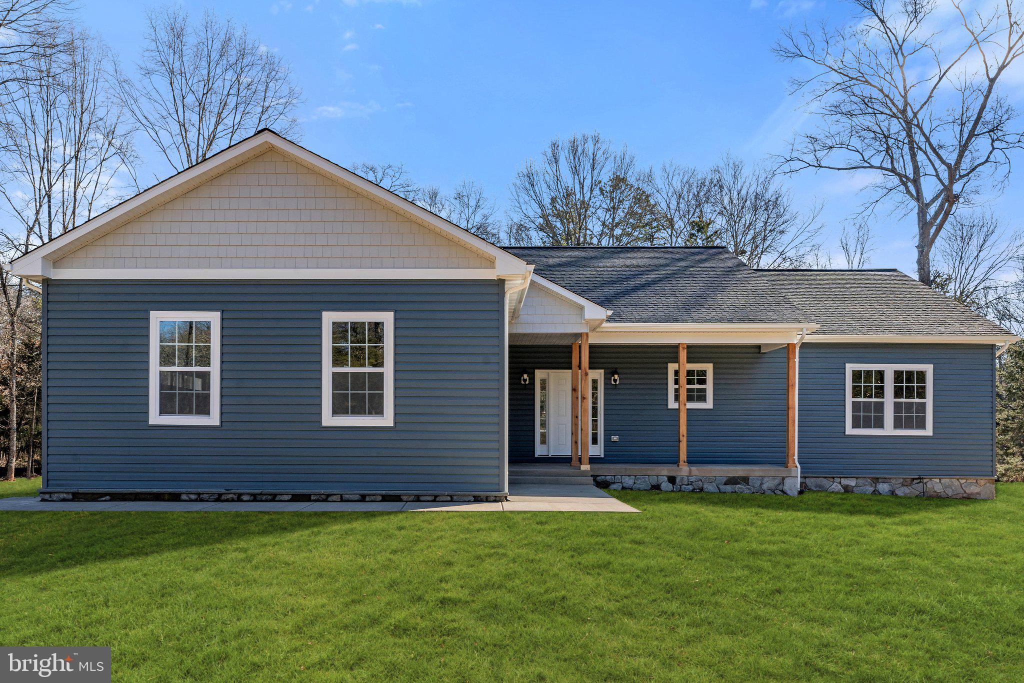 Gorgeous one level new construction home ready for you to move in! Home offers 4 bedrooms and 2.5 bathrooms with an unfinished basement on a wooded 9 acre parcel. Exterior features blue vinyl siding with shaker siding in the peaks, stone foundation on the front of the home, trim around windows, concrete porch with wood columns, and a 12x16 composite deck with black spindles. The interior features black fixtures, 5 panel doors, and luxury vinyl plank flooring throughout. Gourmet kitchen includes white cabinets, quartz countertops, cabinet range hood, cooktop, cabinet pantry, and a peninsula with microwave built in and an overhang for barstools. The living room area offers a wood burning fireplace with stone to the ceiling and cathedral ceilings. The jack and jill bathroom vanity has white cabinets, quartz countertops, double sinks and cabinet pantry with a tiled tubshower.  Master bathroom offers a walk-in closet, separate toilet room, vanity with white cabinets, quartz countertops and double sinks, walk-in shower with a frameless shower door and a transom window for natural lighting. Laundry room off the garage has a slop sink and hookup only for washer and dryer. Garage offers 2 cars, 8' garage door, and painted floors. Video, matterport, and matterport plans are available. Internet is buyers responsibility.