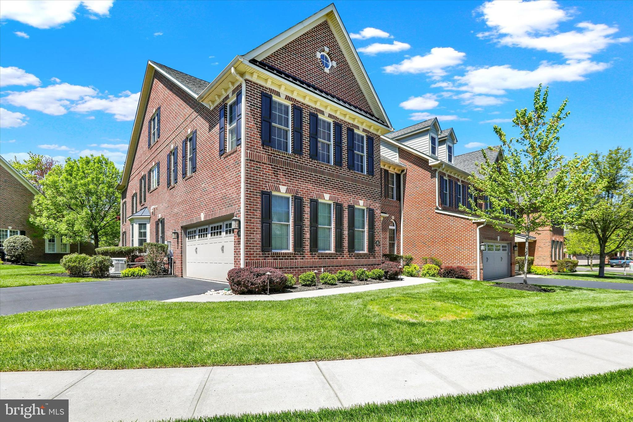 Welcome to 86 Rittenhouse Circle, an exceptional residence nestled within Delancey Court—one of Bucks County’s most coveted 55+ active adult enclaves. Inspired by the enduring elegance of historic Philadelphia, this distinguished community showcases timeless brick Architecture.  Positioned on a premium homesite, this residence backs to preserved open space and a tranquil wooded backdrop, offering a rare sense of privacy and natural serenity. This “McGrath-Built” Madison Model end residence is
thoughtfully designed with three well-appointed bedrooms, a finished third level, a private two-car side-entry garage, and the convenience of a three-stop elevator. Andersen windows throughout enhance both energy efficiency and refined craftsmanship.  A full-house generator (2021) ensures continuous power. A welcoming covered entry opens to a gracious foyer and formal living room, where random-plank engineered hardwood flooring, elegant chair rail, and custom wainscoting create an atmosphere of understated sophistication. The main level unfolds into a seamless open-concept design, anchored by a gourmet kitchen featuring Century cabinetry, under-cabinet lighting, granite countertops, and a striking travertine tile backsplash with custom mosaic detailing above the cooktop. A two-tier granite island flows into the adjoining breakfast room. Premium stainless steel appliances include a KitchenAid five-
burner cooktop, wall oven and microwave, dishwasher, and a recently installed LG Signature refrigerator (2024). The breakfast area is further enhanced by additional cabinetry, a built-in desk, and continued
hardwood flooring. Through double-pane sliding glass doors, an expansive EP Henry patio awaits—beautifully enclosed and framed by a brick privacy wall, overlooking serene, lightly wooded open space—an ideal setting for outdoor entertaining or quiet relaxation. The formal dining room is richly detailed with crown, chair, and custom millwork, offering an elegant space for hosting. The two-story family room is bathed in natural light from a soaring wall of windows, complemented by custom window treatments and remotely controlled Hunter Douglas solar shades. A stunning two-story fieldstone gas fireplace
with a wood mantle serves as the focal point, while a well-appointed dry bar with granite countertop and wine storage enhances the home’s appeal for entertaining. A gracefully turned staircase leads to the second level, revealing an expansive loft-style hallway with a balcony overlooking the family room below. This level features a well-equipped laundry room, a hall bath, and generous storage. The luxurious owner’s
suite is a private retreat, complete with a tray ceiling, refined moldings, and an expansive walk-in closet with custom organization. The spa-inspired bath offers dual vanities with granite countertops, a soaking
Jacuzzi tub, a large walk-in shower with custom tile and seamless glass enclosure, a private water closet, and an additional customized grand walk-in closet. Two additional bedrooms, each with ample closet space, are served by a well-appointed full bath with dual vanity, cultured marble countertops, linen storage, and a tub/shower combination. The finished third level—accessible via both the staircase and the elevator—offers exceptional versatility, ideal for a guest suite, private office, or recreational retreat. This level features charming dormer alcoves, crown molding, built-in seating, recessed lighting, abundant storage, and a dedicated mechanical room housing a second HVAC system. Residents of Delancey Court enjoy an exceptional lifestyle, clubhouse, a fully equipped fitness center, indoor and outdoor pools, and much more. Ideally located near the charming towns of historic Newtown, Yardley, and New Hope Boroughs, with convenient proximity to the PA and JY Turnpikes, it is accessible to New Jersey, Philadelphia, and New York City. This is truly an exceptional home!