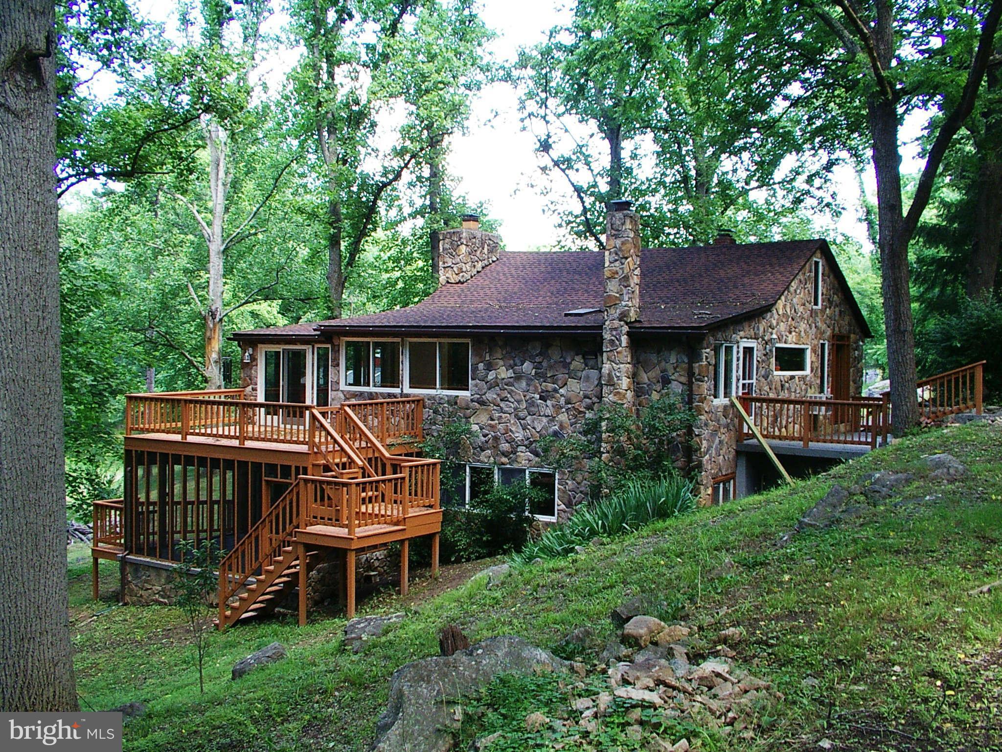 Beautiful & Rustic Stone River House Overlooking the Cacapon River. Two full Kitchens with Ceramic Tile Floors, Hardwood Floors & New Appliances. Brick Fireplace & Wood Burning Stove. A barn with Three Stables. Completely Remodeled. Picture Windows Overlooking The River. Washer & Dryer & Home Warranty. 200 Feet of River Frontage. Street Dead-Ends To the River. Very, Very Private. Over Three Acres.