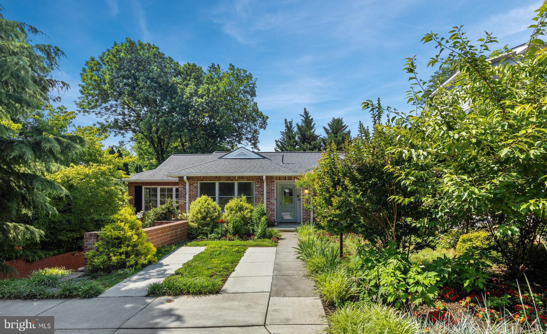 Nestled conveniently off Wisconsin Avenue between Friendship Heights and downtown Bethesda, 4804 Morgan Drive offers a rare combination of storybook cottage charm and updated modern living, all within the West Chevy Chase neighborhood. From the covered vestibule to the light-filled open floor plan, every corner of this remodeled rambler has been thoughtfully curated. The main living spaces are enveloped in large windows, offering picturesque views of the surrounding gardens. At the heart of the home is a gourmet kitchen equipped with quartz countertops, a generous island, and an induction cooktop—perfectly positioned next to a dining area designed for large-scale entertaining. Three serene bedrooms on the main level include a primary suite featuring a pristine white bath and custom walk-in closet. The architectural staircase descends to a bright, walk-out lower level. This flexible space offers a spacious family room, complemented by a full bath with a jetted tub and two additional legal bedrooms (or work space), offering an ideal setup for long-term guests or a quiet professional office. Fully updated within the past decade with a new roof, windows, HVAC, plumbing, and electrical, it also features owned solar panels that reduce the average monthly electric bill to a mere $44 (past 12 months). Outside, the chemical-free, pet-and-kid-safe property is a perennial paradise, featuring Crape Myrtle, Hibiscus, a Kwanzan cherry tree, flowering dogwood, roses, mini magnolias, hostas, evergreens, and more. Enjoy the outdoors from the backyard natural stone patio or the hidden front-entry niche, perfectly positioned by sweet-smelling honeysuckle.