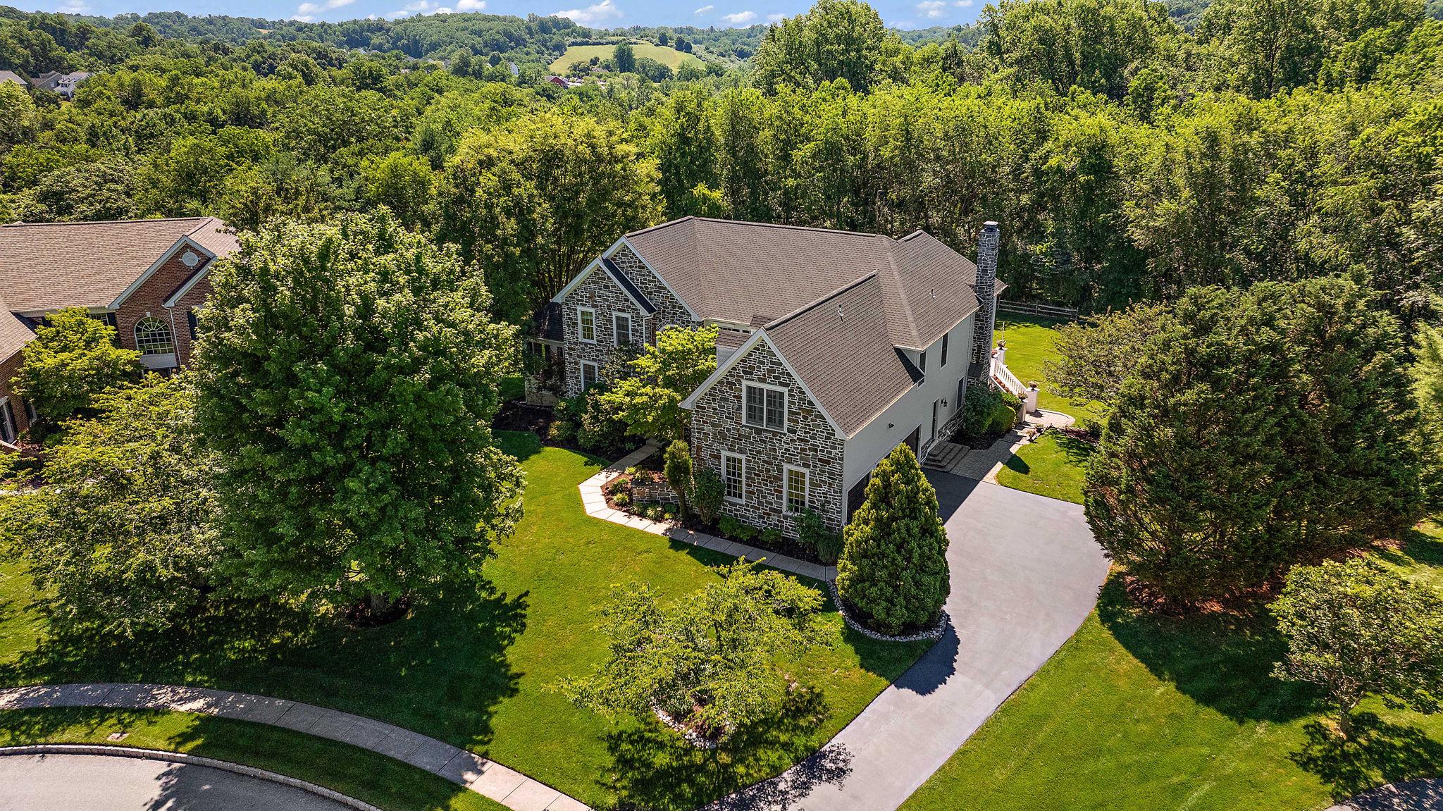 An extraordinary opportunity awaits within the coveted Estates at Tattersall, one of West Chester's most prestigious enclaves and moments from the championship fairways of Broad Run Golfer's Club. Set on one of the community's most exceptional lots, this magnificent residence commands attention from the moment you arrive. The timeless façade of real stone and Hardie Plank siding speaks to a level of quality craftsmanship that endures.Spanning over 5,200 square feet within the nationally acclaimed Downingtown School District, this home has been thoughtfully curated for the most discerning buyer, one who demands both grand-scale entertaining and effortless everyday luxury. Four generously proportioned bedrooms and three and a half elegantly appointed bathrooms establish an atmosphere of refined comfort throughout. Step inside to a soaring foyer that gracefully opens to an expansive, light-filled floor plan. The chef's kitchen is nothing short of extraordinary, anchored by a Sub-Zero refrigerator, Viking cooktop, Thermador oven, Bosch dishwasher, and appointed with upgraded countertops, an oversized island, and a butler's pantry befitting the most lavish of gatherings. The sunlit breakfast area provides an intimate retreat for morning coffee, while the formal dining room stands ready for elegant evening entertaining. The family room, graced with crown moldings, recessed lighting, and a wood-burning fireplace, offers a warm and inviting sanctuary at the end of the day. A main floor laundry and secondary staircase add seamless functionality to the home's impeccable design. The primary suite is a true retreat unto itself, a serene haven featuring two generous walk-in closets and a spa-caliber bathroom with soaking tub, stall shower, and dual vanities. Two large bedrooms share a jack and jill bathroom while the fourth bedroom has it's own full bathroom offering comfort and privacy for family and guests alike.
Beyond the walls, the outdoor experience is equally spectacular. The showstopping terrace-style deck, framed by stone-wrapped columns, is an entertainer's dream complete with a built-in Viking grill, kegerator with dual tap handles, and a bar countertop with seating for four. Set on 0.56 lush acres within a tranquil cul-de-sac, the manicured grounds offer sweeping garden and lawn views that invite both lively gatherings and quiet reflection. A three-car side-entry garage with and huge walk out basement completes this exceptional offering. Homes of this caliber, with this level of finish and location are rarely available. Welcome home!