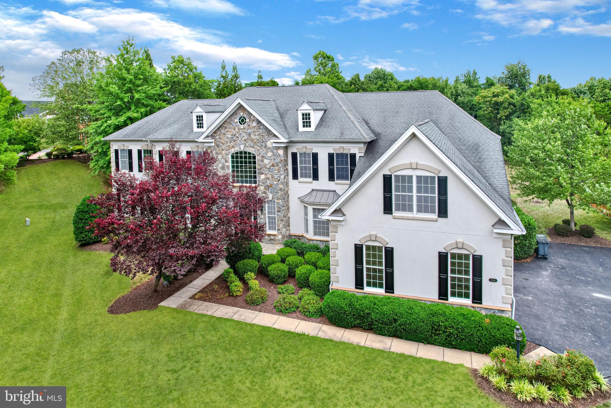 Welcome to 5346 Chaffins Farm, a beautiful, freshly painted home in  the Gated Community of Dominion Valley County Club.  Upon entering the home, you are welcomed by soaring ceilings and a grand double staircase that sets an elegant tone for the home. An abundance of windows bathes the space in natural light, enhancing the gleaming Brazilian cherry wood floors that flow seamlessly throughout all 3 levels of the home. Crystal chandeliers adorn the main and upper levels, adding a touch of opulence.

The formal dining room, adorned with wainscoting, leads to the chef’s kitchen, which is a culinary dream featuring stainless steel appliances, granite countertops, a wine fridge, and ample cabinetry. Enjoy your mornings in the sun-filled breakfast nook. The adjacent great room, perfect for entertaining, boasts a floor-to-ceiling stone fireplace and a coffered ceiling, creating a warm and inviting ambiance.

The main level also includes a formal sitting room, a library with custom built-in bookcases, two half bathrooms, a laundry room, and an airy sunroom, providing ample space for both relaxation and productivity.

Ascending to the second level, you’ll discover the generously sized primary bedroom with an ensuite that features a jetted soaking tub, dual vanities, and a standalone shower. Three additional spacious bedrooms and full bathrooms complete the second level, offering comfort and privacy for all.

The finished basement adds to the home’s versatility with two additional bedrooms and another full bathroom, and two sets of walk up exits, one leading to the back yard, the other to the 3 car garage . The main area is wide open and has already been pre-wired for a home theater.

The Dominion Valley community offers an array of amenities, including pools, basketball courts, trails, golf courses, and a clubhouse. Proximity to parks, playgrounds, and the Dominion Valley Country Club enhances the appeal. Schedule your private tour today to experience this exceptional home.