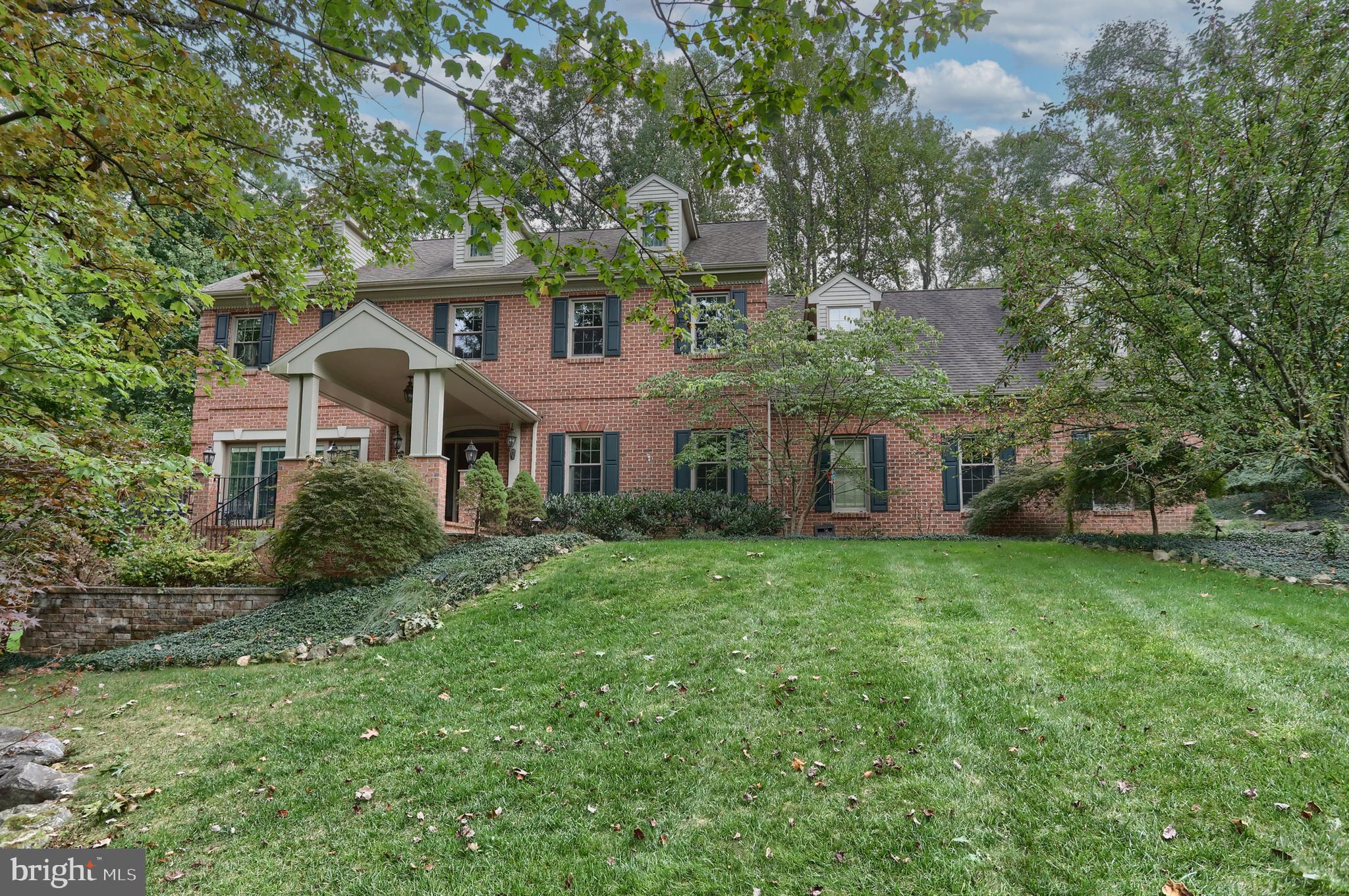 Welcome home to this stunning brick and stone beauty, tucked away on a quiet cul-de-sac in the desirable Stoney Run community. Surrounded by mature trees on nearly an acre, this 4-bedroom, 4.5-bath home offers privacy, charm, and convenience—just minutes from Hershey Medical Center, highways, and attractions. A walking trail circles the property, creating your own private retreat right at home. 
Inside, you’ll love the warmth of hardwood floors, a cozy gas fireplace in the living room, and a sun-filled Sunroom with skylights and a wood-burning fireplace. The chef’s kitchen features a gas cooktop, wall oven, pantry, and opens to a formal dining room—perfect for gathering with family and friends. The upstairs primary suite is a peaceful escape with hardwood floors, a jetted tub, double sinks, and walk-in closet. Three additional bedrooms, a Jack & Jill bath, and a bonus room with built-ins and window seats add comfort and character. The finished walkout lower level with a family room and bar extends your living space and opens to a patio with a koi pond. With three patios, a composite deck, a three-car garage, shed, and your own private walking trail, this home offers space to relax, entertain, and enjoy every season.