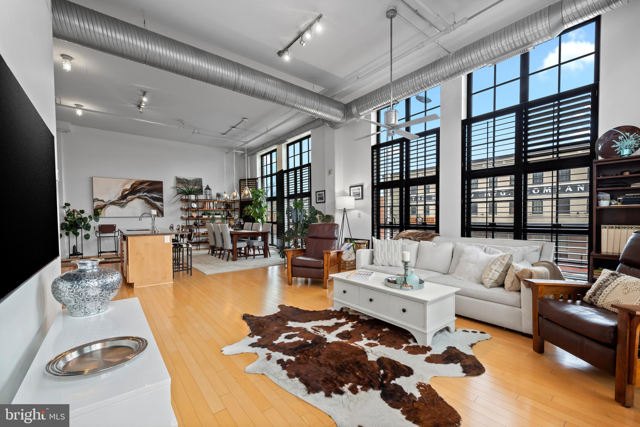 Light, volume, and unmistakable character define this residence at the historic Canal Street Malt House in the heart of Little Italy. This 2-bedroom, 2-bath condominium offers a sophisticated blend of industrial charm and modern comfort, where soaring ceilings, rich hardwood floors, and expansive windows create an atmosphere that feels both airy and inviting. Natural light pours into the open-concept living space, designed for effortless entertaining and easy everyday living. The kitchen serves as the centerpiece of the home, featuring stainless steel appliances, a gas range, built-in wine refrigerator, and seamless connection to the main living and dining areas. A full-size washer and dryer add everyday convenience. One of the building's most distinctive features is its private interior courtyard—an unexpected urban oasis that offers a sense of calm rarely found in city living. Secure entry and a dedicated parking pad provide comfort and peace of mind.
Just moments from the waterfront, Harbor East, Fells Point, and downtown Baltimore, this residence places some of the city's most sought-after restaurants, cafés, and cultural destinations right outside your door. Vibrant yet relaxed, historic yet contemporary, this is Little Italy living at its best. Live where Baltimore's energy, architecture, and lifestyle come together effortlessly.