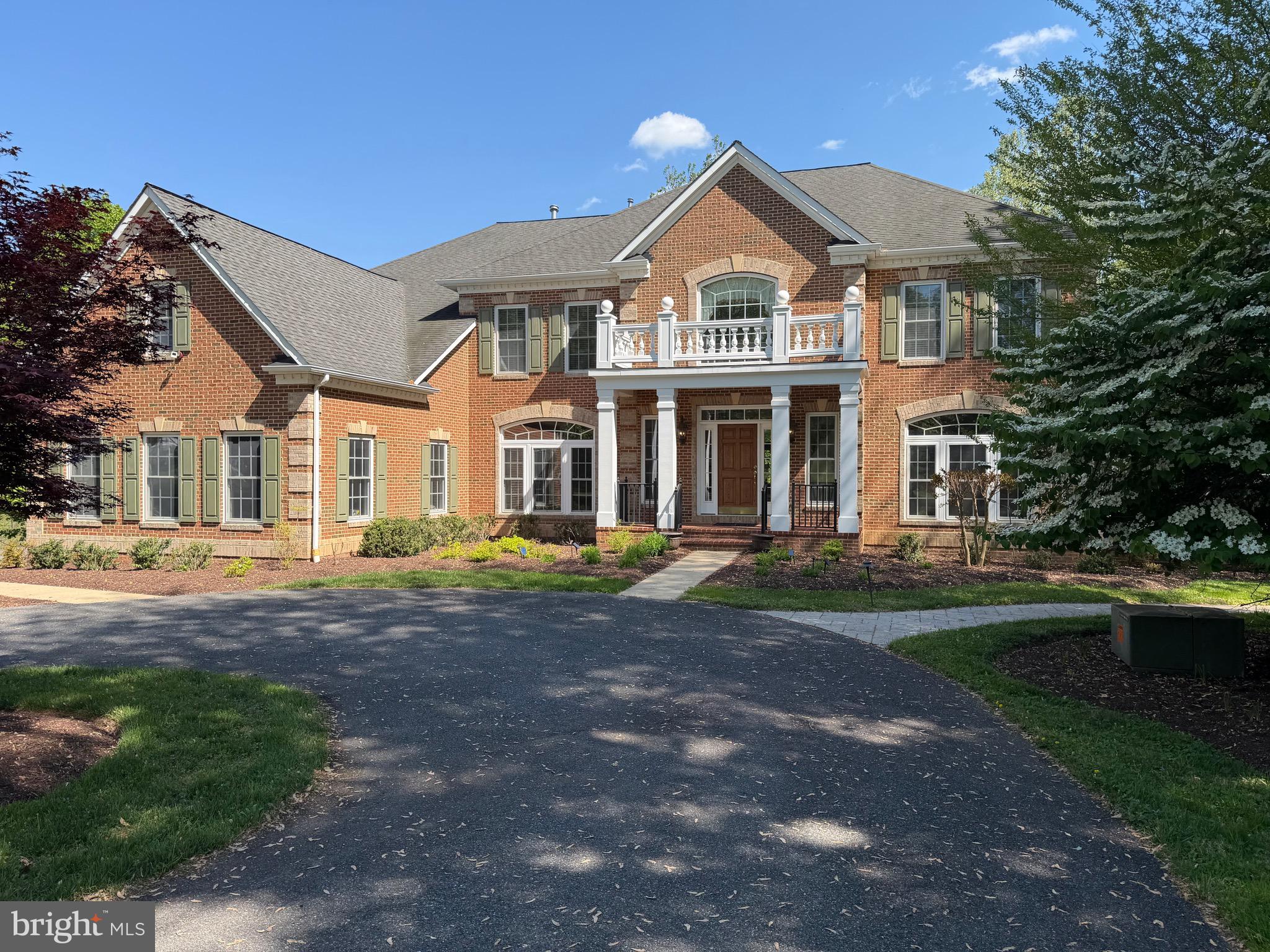 A rare opportunity to own a private estate setting in North Potomac, offering 2.5 acres of space, scale, and architectural presence just minutes from the C&O Canal and within easy reach of Washington, DC.

This custom built residence is defined by grand proportions and timeless design. A stately brick exterior, circular driveway, and mature landscaping create a strong arrival, while hardwood floors, soaring ceilings, and Corinthian columns carry that sense of scale throughout the home.

A two story foyer with dual staircases opens to formal living and dining rooms, while a light filled conservatory provides a quiet, sunlit retreat. The gourmet kitchen features granite countertops, custom cherry cabinetry, high end stainless steel appliances, and a large center island, flowing into a bright morning room with expansive windows overlooking the property.

The two story great room offers a coffered ceiling, a large window, and a gas fireplace with custom built ins, creating a central gathering space. A private library completes the main level.

Upstairs, the primary suite offers a spacious retreat with tray ceiling, sitting area, and a large walk in closet. The primary bath includes a soaking tub, dual vanities, and a glass enclosed shower. Three additional bedrooms each include en suite baths and walk in closets.

The walkout lower level provides flexible living space with a large recreation area, guest suite with a full bath and walk in shower, a second fireplace, wine storage, and additional space for future customization.

Outdoor living includes a pool, gas grill, and a two tier stone patio and deck designed for both relaxation and entertaining.

Convenient access to I 270, River Road, and the Capital Beltway, with shopping, dining, and everyday amenities nearby.