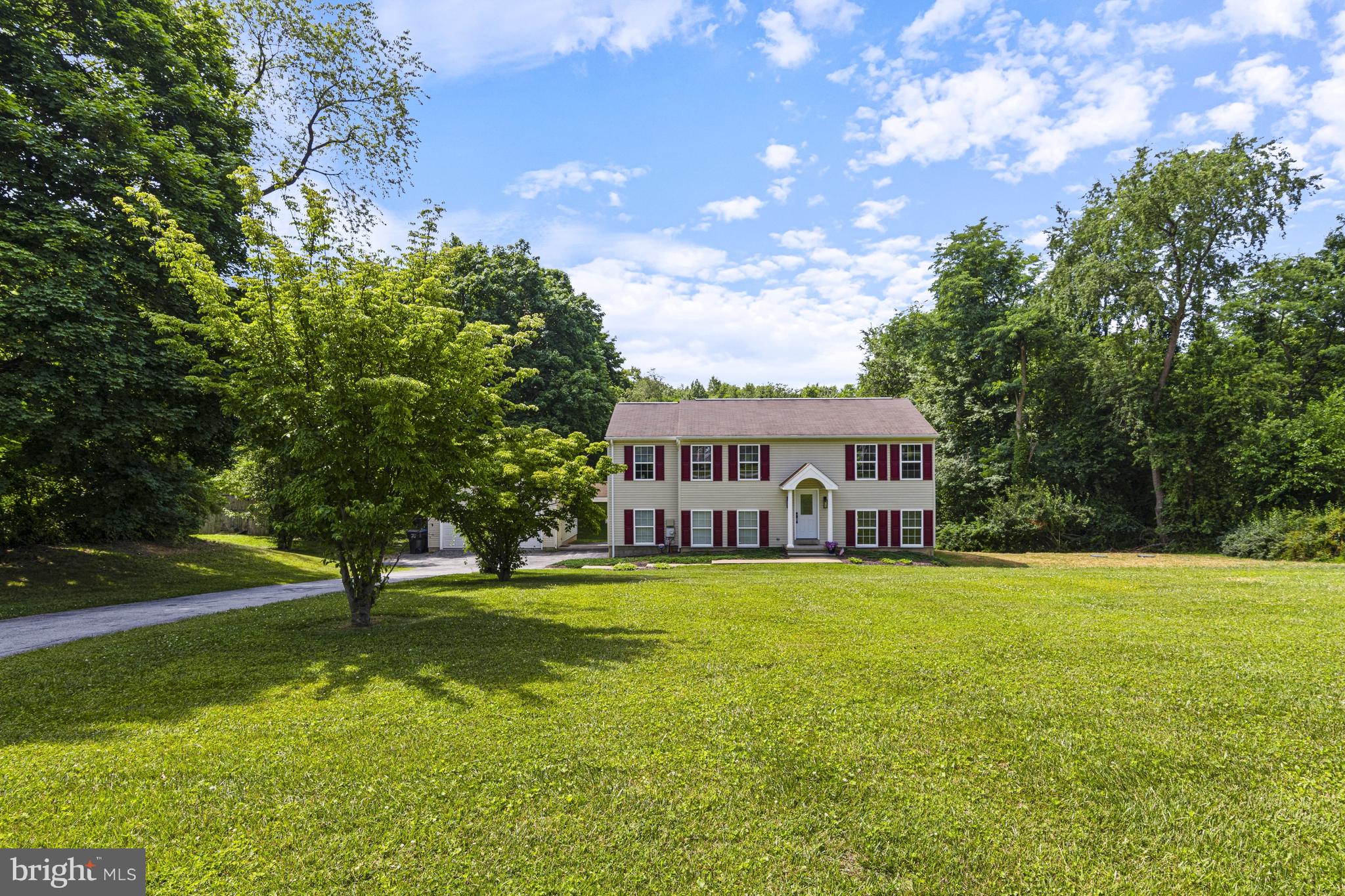 Welcome to this beautifully maintained 4-bedroom, 3.1-bath split-level home nestled on a private, scenic 2-acre lot surrounded by mature trees and peaceful wooded views. Offering the perfect balance of privacy and convenience, this property provides flexible living spaces both inside and out. A bright, welcoming foyer leads to the main living level, where a spacious living room flows seamlessly into the updated eat-in kitchen. The kitchen features granite countertops, a hammered copper apron-front sink, copper backsplash, abundant cabinetry, built-in storage, and a spacious dining area. French doors open to an elevated deck overlooking the expansive backyard and surrounding woods—an ideal setting for outdoor dining, entertaining, or simply relaxing and enjoying the peaceful surroundings. The main living level also includes a spacious primary suite with a private bath, along with two additional bedrooms and an updated hall bath. The lower level offers a generously sized family room, powder room, and laundry area. Also located on the lower level is a private fourth bedroom/studio featuring its own entrance, kitchenette, and full bath, creating exceptional flexibility for extended family, guests, an au pair, a home office, or other private living arrangements. A covered breezeway connects the home to the two-car garage, while an additional stone driveway provides abundant parking for multiple vehicles, boats, RVs, horse trailers, utility trailers, or recreational equipment. Combining flexible living space, exceptional privacy, and a beautiful natural setting, this property offers the tranquility of country living while remaining just minutes from shopping, dining, parks, and major commuting routes. Conveniently located just minutes from the brand-new Doe Run Elementary School, opening for the 2026–2027 school year, providing access to one of the district’s newest state-of-the-art educational facilities.
