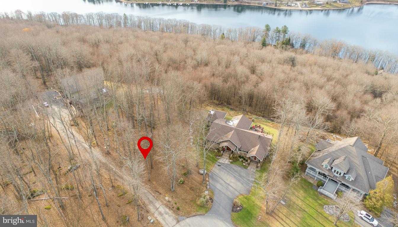 Sweeping lake and mountain views define Lot 13 in Deep Creek Highlands, set on a quiet cul-de-sac with gated access. The land sits adjacent to a wooded common area, giving you quick trail access to the outdoor pool, tennis court, playground, and pavilion. Minutes from your deeded dock slip on Deep Creek Lake. Public utilities are available, and the community covers road care, common area upkeep, and snow removal. Centrally located to local restaurants, state parks, and Wisp Resort. A simple, four-season setting ready for a clean build in one of the mountain’s most established neighborhoods.Call today for details!
