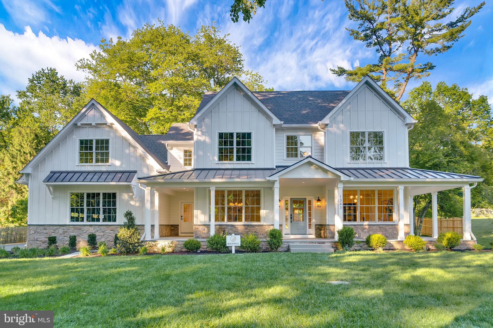 Spectacular new-construction farmhouse colonial in sought-after Glenhardie, beautifully finished and ready to welcome you home! Expertly crafted by Rockwell Custom Homes, this exceptional residence combines timeless architectural appeal with modern, sophisticated living. The wraparound flagstone porch with stately, standing-seam metal roof welcomes all, offering the ideal place to relax, entertain and savor the surrounding scenery. Inside, the bright, thoughtfully designed interior features amenities galore, including wide-plank hardwood floors, exquisite millwork, Kohler® fixtures, designer lighting, soaring ceilings and Quartz countertops throughout. At the heart of the home is a stunning, open-concept kitchen and family room made for effortless living and entertaining. The chef’s kitchen features premium appliances, inset cabinetry, a farmhouse sink and oversized, versatile island that seamlessly anchors the space. Steps away, the breakfast room is bathed in natural light thanks to a cathedral shiplap ceiling, large picture window and glass sliders that open to the rear patio and yard. The adjoining family room is equally impressive with its coffered ceiling, gas fireplace and views of the greenspace just beyond. On the other side of the kitchen, you’ll find a beautifully appointed butler’s pantry with wine refrigerator, sink and abundant cabinetry. An adjacent mudroom with custom cubby and bench storage adds convenience while access to the attached three-car garage is mere steps away. The main level also features an elegant dining room ideal for both large parties and intimate gatherings, a private home office with French doors and two powder rooms. Upstairs, the luxurious primary suite offers a sumptuous retreat with dual walk-in closets and a spa-like ensuite bath with oversized glass shower and soaking tub. This level also boasts three spacious secondary bedrooms—one with an ensuite bath and two connected via Jack-and-Jill bath—plus a laundry room with sink and custom cabinetry. A generously sized fifth bedroom sits at the end of the hall complete with large closet and expansive ensuite bath. More space awaits in the finished lower level, including an open lounge area, media room, wet bar, full bath, storage and endless opportunities for entertaining and play. Outside, enjoy a lovely flagstone patio and yard perfect for recreation and dining under the stars. For low-maintenance living and peace of mind, this home also boasts a new driveway, sewer and water lines, plus a buried propane tank. Endless opportunities and conveniences await mere minutes from your front door, including the 3,500-acre Valley Forge National Park and its miles of scenic trails, award-winning Tredyffrin/Easttown schools, Gateway Shopping Center, Wilson Farm Park, King of Prussia Mall and Town Center and major commuter routes. Don’t miss this rare opportunity to enjoy new construction in one of the Main Line’s most desirable communities!