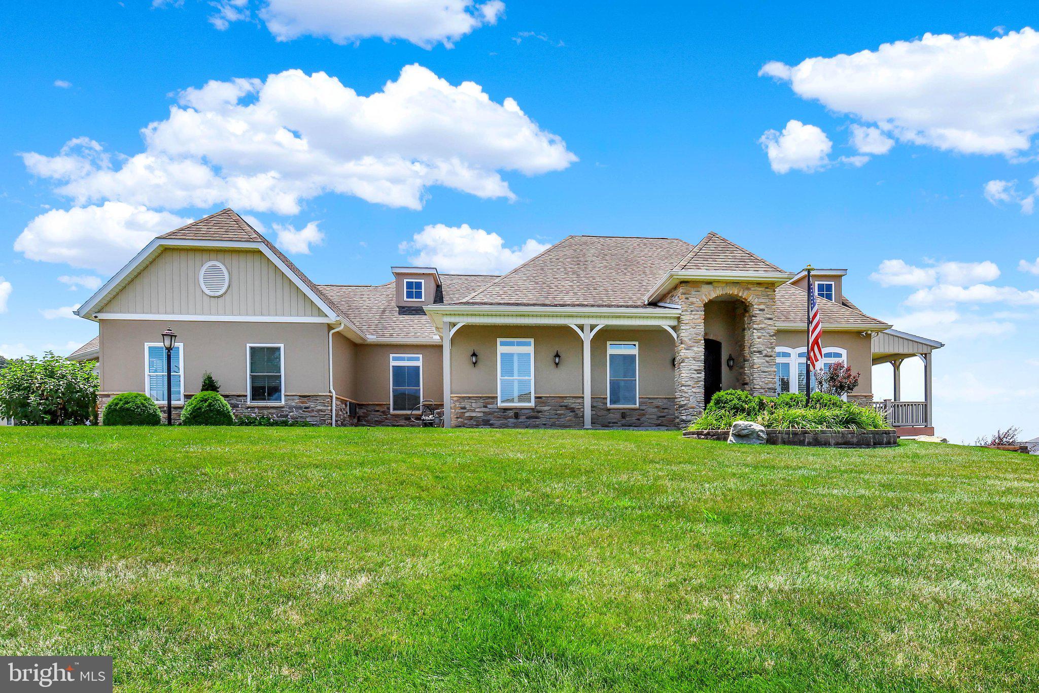 Welcome to Penn National Community. An amazing place to call "home"! Step through the custom front door and see all the ways this space can be your own. The thoughtfully designed main level offers an open, light-filled layout with exceptional flow, creating an inviting space for both everyday living and entertaining. A formal dining room, comfortable sitting area with a gas fireplace, and a chef's kitchen featuring dual sinks, large pantry, and abundant counter space make hosting effortless. Step outside to the spectacular screened porch and adjoining deck, where panoramic views provide the perfect backdrop for relaxing or entertaining, connected to a stone-paved patio. The main level also offers a private retreat with a spacious primary suite featuring a cozy sitting nook, walk-in closet with custom shelving and drawers, and pocket doors for added privacy. The luxurious en-suite bath includes radiant heated floors and a zero-threshold tiled shower for comfort and accessibility. The main floor is completed by a home office, along with a generous laundry room enhanced by skylights. An elevator provides convenient access to the finished walkout lower level, which offers a large living area, two additional bedrooms, and a Jack-and-Jill bath with radiant heated floors. The lower level also includes extensive workshop and project space with a utility sink and direct access to the backyard. Completing the property is an oversized multi-car garage featuring climate control and two separate workshop or hobby areas, making it ideal for projects, storage, or creative pursuits. Lovely walkable community offers 36 holes of 4-star golf, outdoor pool, tennis/pickleball, yoga, community garden, hiking in Michaux State Forest, 40 + social clubs, restaurant/bar, coffee shop, and so much more! See Pro Shop for membership details.