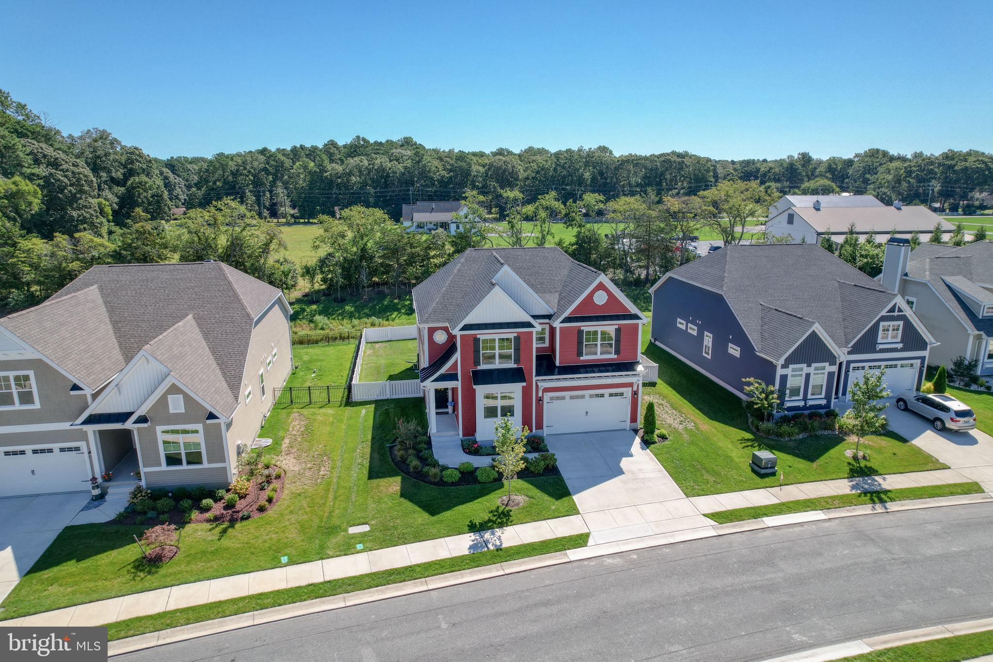 Seriously, where are you going to find a Schell Brothers  home with a LEWES address in the Cape Henlopen school district for this price? NO WHERE! Welcome to Hailey’s Glen, a sought-after Schell Brothers community in Lewes, Delaware. This less than two-year-young craftsman-style home rests on a private fenced in lot. As you walk onto the charming and inviting front porch you're immediately welcomed into an open floor plan bathed in the natural light, seamlessly blending modern convenience with the tranquility of a coastal warm retreat. The chef’s kitchen has all the modern conveniences with a large center island, double wall oven, induction cooktop and is open to the dining area and the great room, where vaulted ceilings frame the peaceful backyard views.
On the main level, the spacious primary suite has trey ceilings and offers two large walk-in closets and a spacious primary bath. An inviting first-floor office provides the perfect space for work or quiet reading, while custom touches such as hallway shiplap add warmth and character.
Upstairs, a large airy loft offers flexibility for recreation or relaxation, joined by three additional bedrooms, a full bath, and impressive storage space which can expand to a fifth bedroom if desired. Outdoors, the generous yard has ample room for a private pool, creating the perfect setting for entertaining or unwinding at day’s end. Beautiful LVP flooring adds warmth throughout the home.
Just minutes from Delaware’s famous beaches, fabulous dining, shopping, and convenient access to Route 1, this home offers not just a place to live but a true coastal lifestyle.