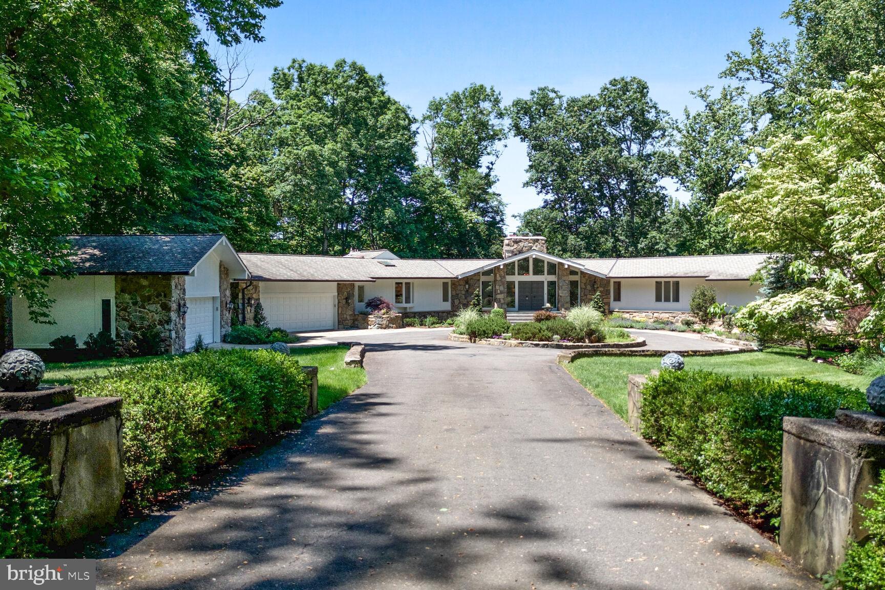 Fall in love with this peaceful, tranquil, custom-built home nestled on over five acres of wooded land close to the Potomac River and Riverbend Park. Your private oasis in the hustle and bustle of the DC area is accessible via a gated entrance and a circular driveway. A grand foyer framed by full stone columns and a soaring cathedral ceiling greats you as you enter the home. Behind the massive, recently renovated, fieldstone fireplace, a two-story glass wall reveals the scenic backyard gardens and woods. This view extends to the adjacent home office, which features a private deck, making it an ideal spot for remote work.

Enjoy outdoor dining or relaxation on one of three decks, spacious patios or move inside to your bright four-season, climate controlled, sunroom offering an immersive view of the changing seasons. The seamless indoor/outdoor connection flows, via new luxury flooring, through the kitchen, sunroom, dining room, and the entire main level, creating a perfect setting for entertaining.  The gourmet kitchen is equipped with top-tier Viking, Sub-Zero, and Bosch appliances.  

The main level includes two bedrooms and a luxurious primary suite. The hall bathroom, with a spa-like air-jetted tub, is cleverly divided by a pocket door to allow simultaneous use. The primary suite boasts its own deck, an air-jetted tub, steam shower, skylights, and breathtaking views, providing a serene personal retreat. 

The lower level, illuminated by a full wall of windows, offers an ideal space for entertaining. An expansive recreation room with a wet bar and a 9-ft pool table provides ample space for family or guests, seamlessly connecting to the main living area for larger gatherings. This level also includes a home gym, a fourth bedroom, a full bath, and a large den.

A large detached two-car garage, in addition to the attached two-car garage, caters to car enthusiasts and hobbyists. Two acres are enclosed by a deer fence, and an oversized generator adds extra peace-of-mind. This extraordinary home, with its high-end finishes, fresh paint throughout the interior and exterior, and low-maintenance gardens, exemplifies pride of ownership.