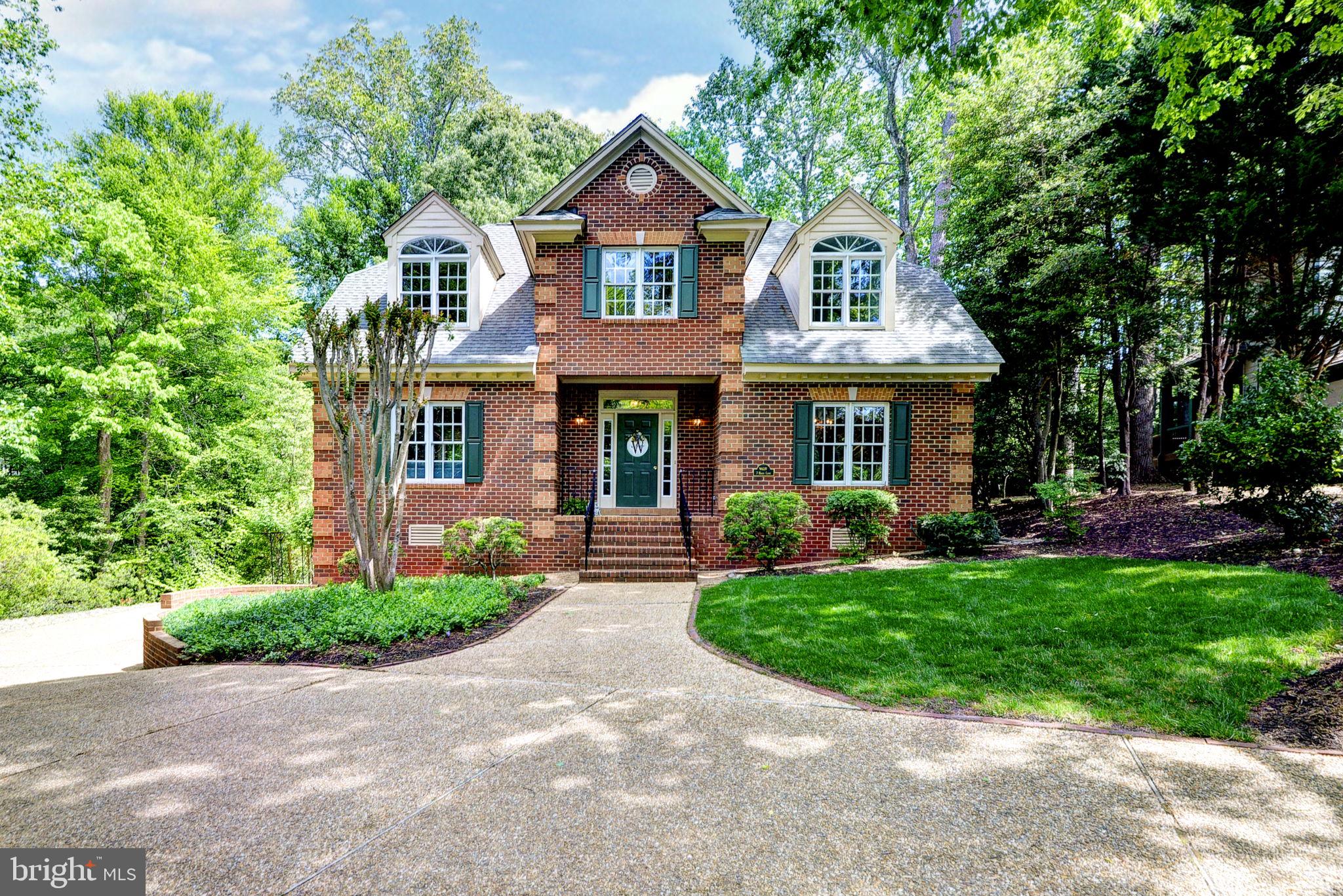 Impeccably maintained, all-brick, traditional home in the coveted Port Anne neighborhood, a short walk from Colonial Williamsburg! Fantastic floorplan with a lovely atrium that opens to the formal living and dining. Take in the serene wooded views from the large family room with a stone fireplace and vaulted ceilings filled with natural light. The kitchen features luxury volga blue granite, newer stainless steel appliances and a lovely eat-in area leading to the screened and full wrap around porch outside!  Upstairs the massive primary suite features its own sitting room and large closets! The en-suite bath has dual vanities, garden tub and standing shower. Two additional bedrooms share another full bath upstairs. Two car garage and easy access to mechanicals in the basement. Stunning landscaping, one of the largest and most private lots in the neighborhood!