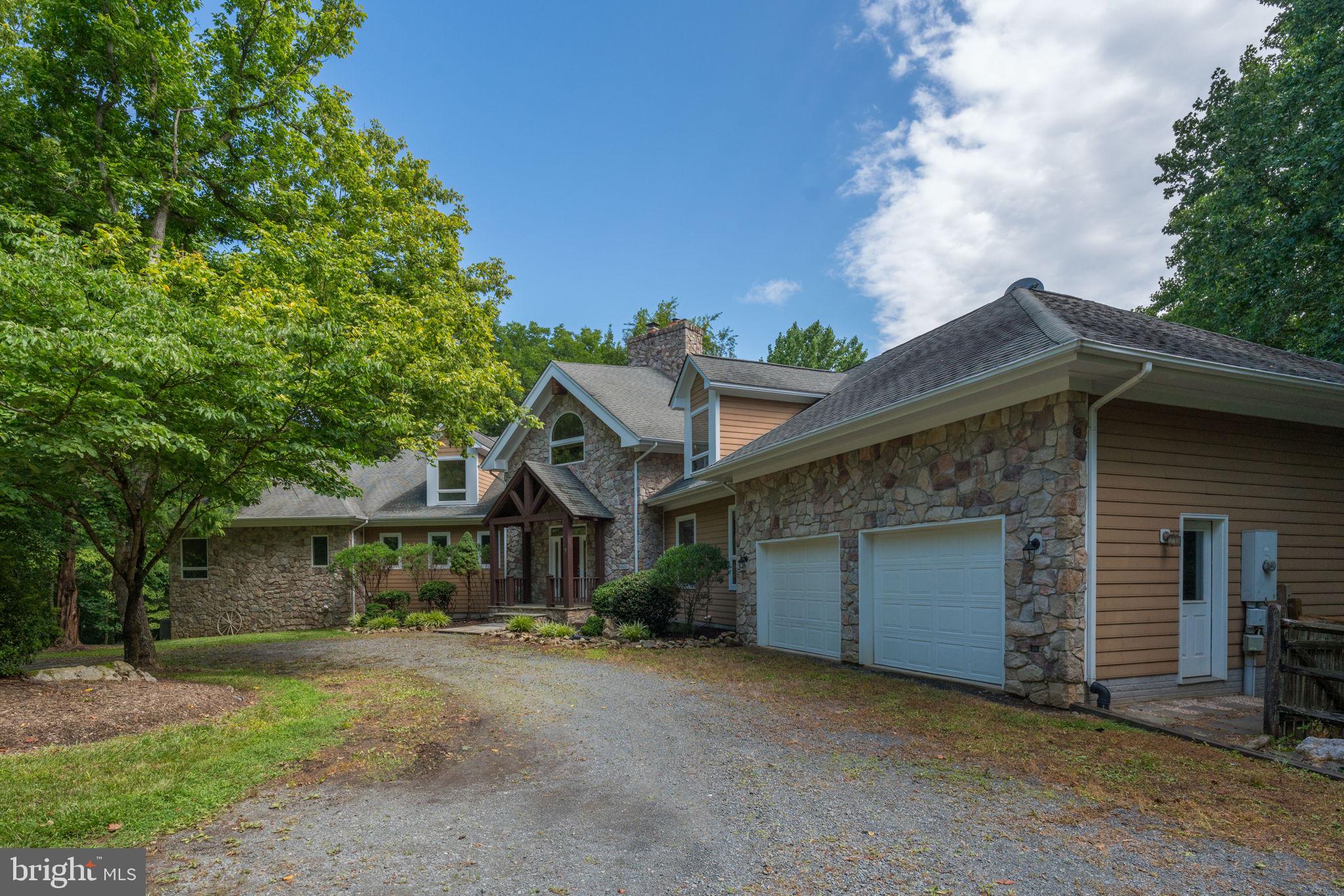 PRICE REDUCTION!  Great opportunity to own a beautiful home in Loudoun County.  Minutes to Leesburg and major roadways.  This could be a perfect location for your new business!  Located on thirty acres and zoned AR2 provides opportunity for any number of business options.  This property is perfect for a corporate retreat, home business, bed and breakfast, art studio, animal services, or even a winery or brewery.  The gorgeous contemporary chalet-style home and the existing oversized outbuilding provides a great basis for a new business.  Per Loudoun County Zoning Department, one can build a 2,500 square foot accessory dwelling unit as well. (Potential purchasers must confirm with Loudoun County).  The home is set up to welcome guests with a main floor primary bedroom/bathroom, second main floor bedroom, two en suite bedrooms on the upper level and an en suite bedroom in the lower level.  The home is spacious with an impressive floor to ceiling stone fireplace, cathedral style wood plank ceiling, and floor to ceiling windows across the back of the great room.  It is a perfect place for gathering together. Welcome guests at the wet bar located next to the great room or venture out onto the deck that spans the back of the house.  The large gourmet kitchen and mud room/butlers pantry is designed to handle entertaining.  Two areas near the kitchen are ideal for a breakfast table and/or dining room table for guests to eat.  The upper level offers a spacious loft that overlooks the great room and features a wood-burning fireplace.  The lower level features a second kitchen area, large recreation room with stone hearth and wood stove, and a huge media room.  A unique feature of the lower level is a bathroom with multiple sinks, showers, and stalls.  Access to the patio and backyard is available through the sliding glass doors across the back of the recreation room.  Plenty of space to spread out and potential hiking down to Goose Creek.  Ideally located near both Leesburg and Middleburg, several wineries/breweries, Oatlands Plantation, Leesburg Outlets and more make this a perfect option for a business to flourish.  Purchaser must perform appropriate due diligence for potential business.