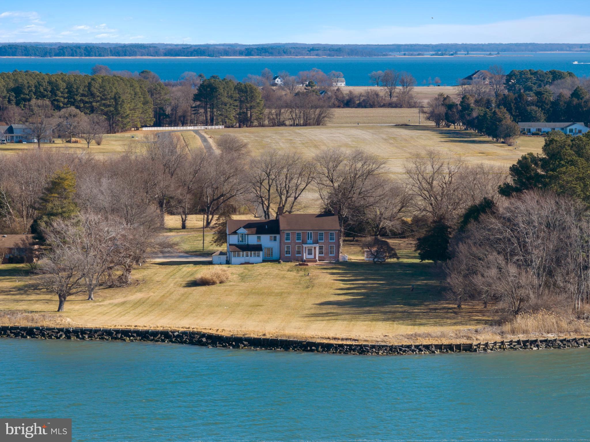 Commanding an exceptional waterfront setting, this timeless historic property offers an increasingly rare opportunity to own a generational retreat defined by land, water, and view. Encompassing 35 acres and approximately 599 feet of shoreline, the property unfolds to a private beach and panoramic vistas across the Bay, where dramatic sunsets and iconic views of the Bay Bridge create a daily backdrop of natural beauty and quiet spectacle. With ample frontage and the potential for a private pier, the setting invites a true waterfront lifestyle. Enjoy boating, paddleboarding, lounging at the waterfront, and relishing evenings spent watching the light change across the water.

Much of the acreage is designated agricultural, offering meaningful tax advantages while preserving the open, pastoral character of the land. This combination of expansive waterfrontage, open fields, and protected views creates a sense of scale, privacy, and long-term value that is rarely found. 

The historic residence, lovingly maintained by multiple generations, serves as a gracious complement to the land rather than its focus. An authentic, well-preserved home that anchors the property without overshadowing its extraordinary setting. 3 bedrooms, 2 baths, hardwood floors, original architectural details, and generously sized rooms reflect a quieter era of craftsmanship and care, while multiple windows throughout capture water views from nearly every vantage point.

This is a property of substance and legacy—where expansive shoreline, agricultural land benefits, and one of the Bay’s most recognizable views converge to create an unparalleled waterfront offering. Welcome Home!