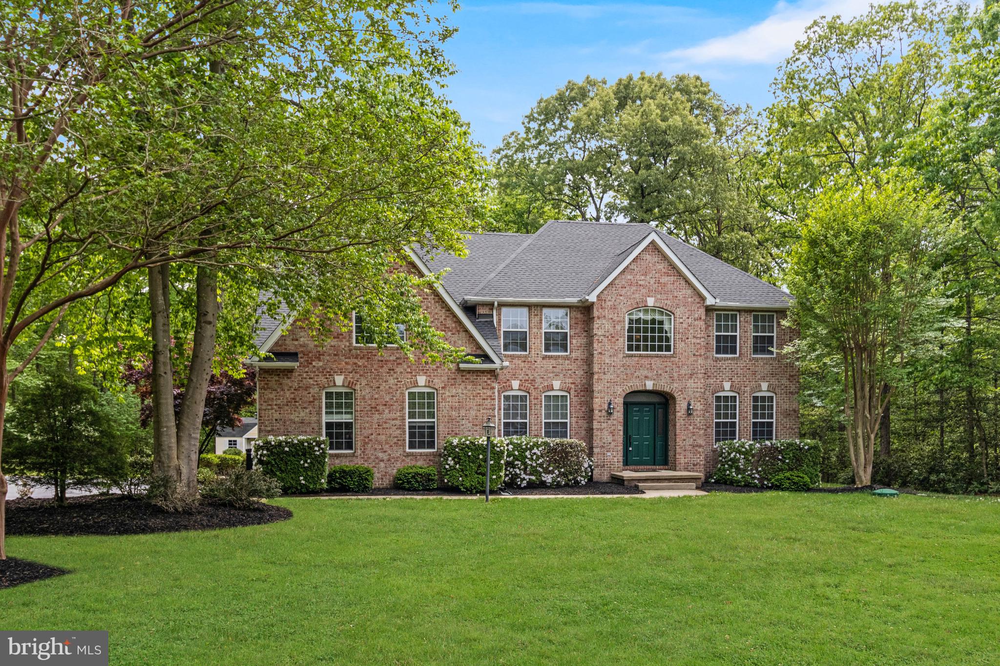 New Price! Potential VA loan assumption available at approximately 2.7%, subject to lender/servicer approval and buyer qualification. Set on a beautifully landscaped 2.6-acre lot in the sought-after Locust Grove community of Port Tobacco, this meticulously maintained brick residence offers a rare combination of privacy, space, and meaningful updates. With nearly 5,000 square feet of finished living space, the home offers 4 bedrooms and 3.5 bathrooms on three finished levels. Conveniently located for commuters, the property offers easy access to several major military installations including Indian Head Naval Support Facility, Naval Support Facility Dahlgren, and Patuxent River Naval Air Station.

A custom front door welcomes you into a light-filled main level where a two-story foyer sets the tone. Formal living and dining rooms offer classic gathering spaces, while a private office with French doors provides an ideal work-from-home setup.

The kitchen serves as the heart of the home, featuring an island with seating, space for a breakfast table, and a built-in desk area. It opens seamlessly to the two-story family room, where a fireplace anchors the space and creates a warm, inviting setting. From the kitchen, French doors lead to the expansive rear deck, perfect for outdoor dining, quiet mornings, or hosting guests while overlooking the private, tree-lined yard.

Upstairs, the primary suite offers a true retreat with space for a sitting area, walk-in closet, and a fully renovated bath with dual sink vanity, a soaking tub and separate shower. Three additional bedrooms and a beautifully updated hall bathroom are also on the upper level.

The finished lower level adds exceptional flexibility, complete with a built-in cherry wet bar, a full bathroom, and multiple bonus spaces including a second office, recreation area, and an additional room with a closet that can function as a guest suite or fifth bedroom. A walk-up exit enhances convenience and access to the backyard.

Recent improvements include a new roof (2021), HVAC system (2022), water heater (2022), updated plugs and switches, Ecobee thermostats, and fully renovated bathrooms throughout.

Outdoor living is equally well-considered, with a spacious deck, an enclosed hot tub area, two storage sheds, and a 9-zone underground irrigation system supporting the mature landscaping. An oversized two-car attached garage and expansive driveway completes the offering.

A property that delivers space, updates, and a setting that feels both private and connected, 8875 Locust Grove is a standout opportunity in Port Tobacco!