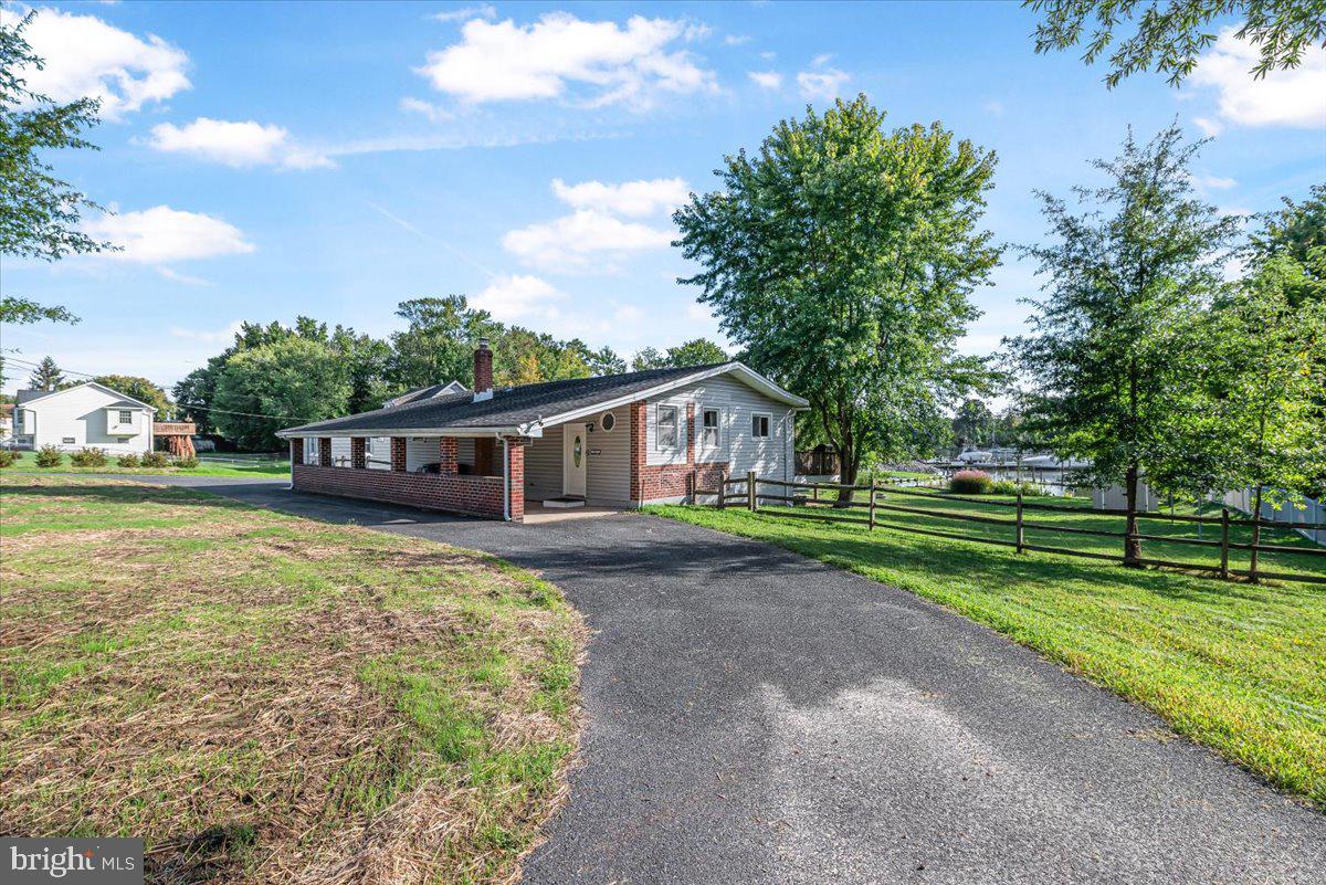 Charming 2-bedroom, 1-bathroom ranch-style home sits on a generous sized lot with access to a waterfront area. Enjoy private access to the water, complete with a private dock site and a boat launch ramp, perfect for water enthusiasts. The home offers a spacious open concept layout providing ample room for relaxation and entertainment.  Additional features range from stainless steel appliances, wide windows, abundant natural light, modern touches and an oversized deck that overlooks the water! Parking is convenient with an attached carport and an extended driveway that can accomodate up to five vehicles. Local amenities include, parks, shops, and dining options. This property presents a rare opportunity come and enjoy the benefits of waterfront living. Don’t miss your chance to own this gem!