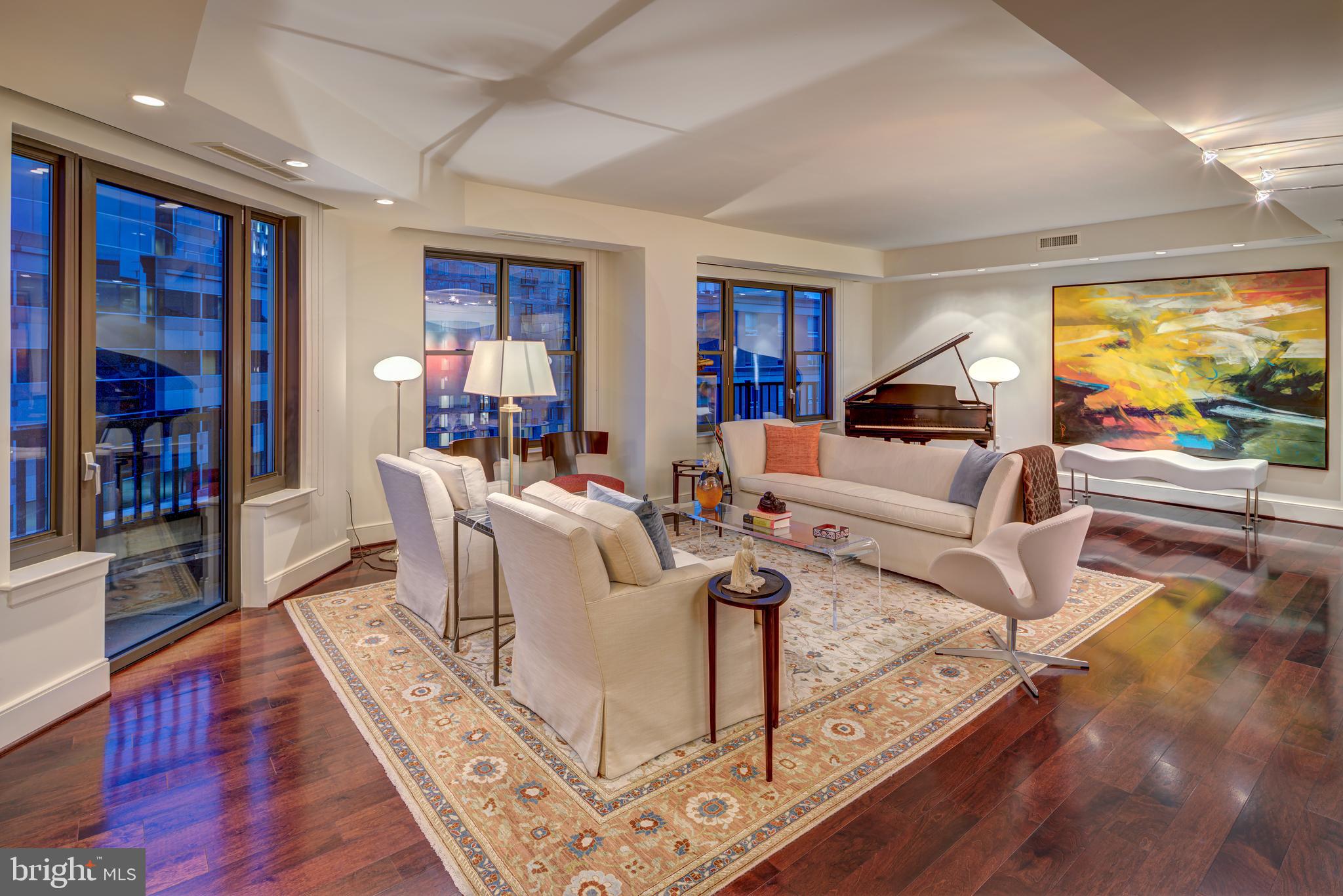 Luxuriate in this rare offering of a spectacular approx  2600SF corner unit in Lionsgate- Bethesda Magazine's 2024 Best Luxury Condo Building Winner!!  Urban sophistication in a tranquil, zen-like retreat, this panoramic model showcases an extensive re-design by Anthony Wilder, with sleek finishes and a thoughtful use of space.  Truly one of a kind, this former 3BR (now with an incredible owners' suite, guest BR/den and office) wraps one of the Woodmont front corners, with abundant natural light through walls of glass and four Juliet balconies.  One is welcomed into the residence through the gallery-style foyer with a custom curved ceiling with cove lighting.  The front-to-back hall also offers a formal powder room, guest closets, and a separate laundry room.  The sun-soaked living room follows and is a wonderful entertaining space, with a grand piano space that flows into the dining room with a built-in shoji screen china cupboard.  The adjacent kitchen features Viking stainless steel appliances, a wine fridge, a center island, and hidden storage recessed into the dividing wall. Custom lighting is throughout, from modern chandeliers, gallery/task lighting, and recessed lighting.  The office follows with its custom desk built-in and open design.  Enjoy your favorite book or show from the adjacent family room/library/guest complete with an en-suite full bath.  The crown jewel of this home is the owners' suite, entered through one of two dressing areas with floor-to-ceiling built-ins, a safe, cedar closets and wine storage, and a rear exit.  This is just a prelude into the bed chamber itself, with more floor-to-ceiling built-in dressers, cabinets, closets, and bookcases, and graced last with an extraordinary spa bath with two vanities, soaking tub, walk-in shower, and separate commode room.  Two ideally located parking spaces convey, as well as a storage unit.  Ensconced in a building two blocks from the Bethesda Metro station, in the heart of the best that Bethesda offers in dining, shops, entertainment, and outdoor fitness, including the Capital Crescent Trail. The Lionsgate is a premiere building with valet parking, 24/7 concierge, doormen, a fitness center and library, a club room/meeting room, and professional, on-site management.  Enjoy sunsets from the rooftop terrace, with a grill, dining, lounging, and entertaining areas. This one-of-a-kind offering is truly exceptional.  Please contact the listing agents to schedule your private tour.