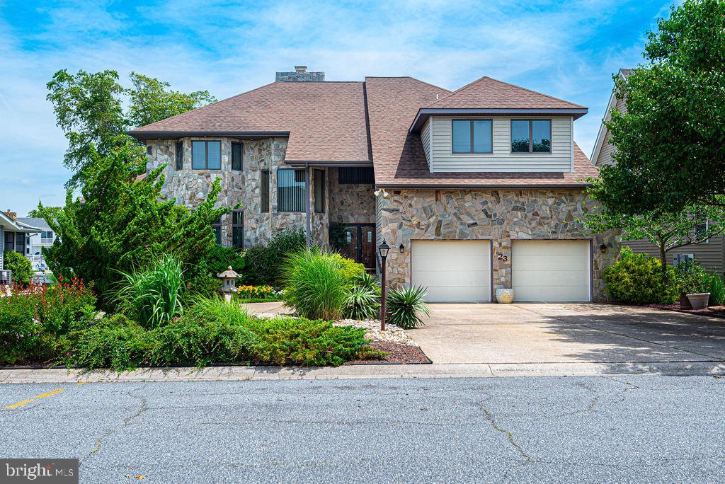 One of a kind  custom designed home! Walk up the grand stone steps and enter thru double doors to a tile foyer with a walk-in coat closet, half bath, and laundry across from the downstairs ensuite that includes two walk-in closets, and a jacuzzi tub plus shower in it's bath. Step down to the hardwood floors of the dining room, great room- with a floor-to-ceiling stone gas fireplace - and a gourmet kitchen including eating area. Upstairs is another ensuite with double lighted closets, corner jacuzzi tub and shower, and two balconies - one indoor, one out.  Also upstairs are two more bedrooms (one with a bonus room), off a hallway with another overlook and three walls of bookcases.  There are five sliding glass doors leading to a wrap around deck overlooking a lovely landscaped backyard that includes a large pond with waterfall, and a dock with boat lift on a wide canal. Additionally, this home has a circular driveway, a two car garage with overhead storage, Andersen windows and doors throughout, huge floored attic, five pocket doors, three newish HVAC systems, a central vac system, a direct propane grill hook up, an outdoor shower, and a climatized encapsulated crawl space.  All blinds convey. Ocean Pines community has 5 swimming pools, golf course,  Yacht Club with restaurant, golf course with club house, and its own fire station and police force.