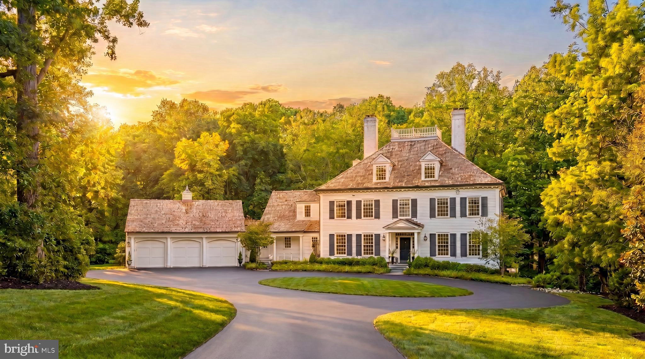 Tucked away behind the nationally-renowned Congressional Country Club, its namesake Country Club Drive is one of Bethesda’s most prestigious streets, with a mere 26 of the very finest estate homes dotted along sweeping curves in a picturesque setting. Within this rarified air, at the apex of a verdant cul-de-sac, is this quintessential colonial estate home. Tucked away far back from the street, its elegant approach is via an elegant circular driveway, revealing a white brick facade capped by a cedar shake roof evoking cues of classic old-world New England colonials situated on large swaths of land, and exuding an ethos of quiet luxury. Contrasting black shutters infuse the classic exterior with a modicum of modernity as one approaches the central front door via flagstone walkway. The blend of tradition and currency is further carried through the interiors, which have been comprehensively reimagined to suit the tastes of a contemporary luxury clientele while retaining its quintessential elegance. A traditional center hall foyer is flanked by embassy sized formal living and dining rooms. The former can be discreetly closed off via pocket doors, enjoying an ethereal palette augmented by natural light flooding in from the Palladian window on its far side, illuminating the roaring fireplace wall flanked by custom built-ins. The latter also showcases a fireplace, one of five in the home, this one featuring a bold, dark marble surround to complement the moody, sophisticated palette à la fine dining establishment – for sophisticated large scale entertaining. A transverse gallery bifurcates the main level’s formal and informal spaces, with the large family room and its wall of glass, rustic floor-to-ceiling stone fireplace wall, and patio access serving as a midpoint. The chef’s kitchen is the heart of the informal wing. Enjoying almost a European-level of minimalism, its white shaker cabinetry and matching counters conceal a comprehensive suite of state-of-the-art appliances, and are contrasted by a dark, full-height backsplash wall. A large family entrance and mudroom, additional powder room, connection to the butler’s pantry, and direct access to the oversized three-car garage are conveniently tucked away in this wing. A private library with built-ins connected to a spacious den surrounded by glass, both with coffered ceilings, completes the main level. A transverse hallway on the upper level commences at the top of the sweeping staircase and mirrors that of the gallery below. The exquisite primary suite spans the entire width of the upper level, with a large bedroom overlooking the lush grounds. The central dressing room is akin to a luxury boutique in scale and layout, with multiple nooks all surrounded by extensive illuminated built-ins. Minimalist yet still lavish, the primary bath boasts the ubiquitous double vanity, freestanding soaking tub, separate water closet, and walk-in shower. Three additional generously proportioned bedrooms, each with a designer ensuite bath, complete the upper level alongside a spacious and conveniently located laundry room. A finished third level comprises two additional private bedroom suites, ideal for young adults, a fitness studio, bonus space, or a fully private telecommuting solution, as well as ample storage space. A comprehensive entertainment zone, the lower level revolves around a substantial recreation room which spans over 47 feet in length. A professional home cinema is found at one end, while a large fitness center and step-down game room, currently set up as a golf simulator, are found at the other. A spa-inspired bath including a full sauna completes the space. The home’s outdoor space is another certain highlight, occupying 2.06 coveted acres in a proximate Bethesda location. The manicured landscaping is complemented by a flagstone patio, comprising a pergola above a modern linear fire pit, full outdoor kitchen, and sunken hot tub.