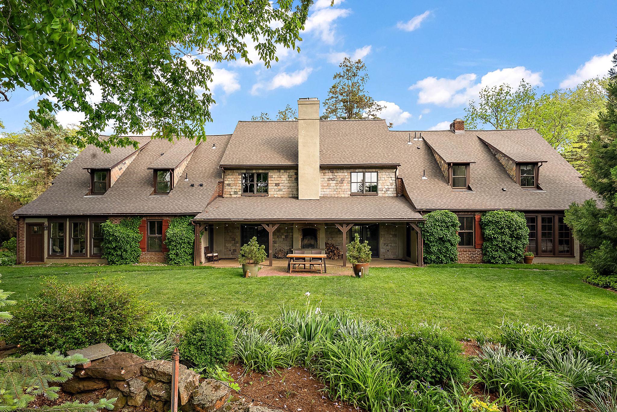 Tucked into the storybook setting of Centreville, this one-of-a-kind home blends timeless European charm with everything today’s buyer is searching for—space, walkability, and peace of mind with major updates already complete. Set beside preserved pastureland, the property offers rare privacy while still being a short stroll from the village’s shops, dining, and playground.

Originally built as two caretaker cottages for a neighboring estate, the home was thoughtfully reimagined into a single, cohesive residence. The result is an architectural gem where old-world craftsmanship meets modern living. Soaring two-story exposed brick walls anchor the dramatic living room, framed by walls of windows that invite natural light from front to back. Exterior slate accents add rich texture and color, enhancing the home’s European feel.

Designed for gathering and entertaining, the home features both indoor and outdoor fireplaces, creating warm, inviting focal points year-round. The layout offers both connection and privacy: the primary suite sits above the kitchen on the east side, while three additional bedrooms occupy the west wing, linked by a balcony overlooking the living space below. A first-floor guest suite with ensuite bath provides ideal accommodations for guests, nanny, or multi-generational living. 2nd Den/family room on first floor or loft area above could be 5th bedroom. 1st and 2nd floor laundry and add'l mudroom add to the convenience.

At the heart of the home, the kitchen is both expansive and cozy, centered around a generous granite island and equipped with dual ovens—perfect for cooking while enjoying views of the surrounding open land and village.

Recent upgrades — including a new roof (2025) and two new HVAC systems (2022/2025) —ensure low-maintenance living. The detached three-car garage adds even more versatility, with nine-foot doors, overhead storage, and an extended patio, complete with hot tub retreat. 

This is more than a home—it’s a lifestyle. A place where charm, comfort, and community come together, and where every gathering feels a little more special. Owner is licensed real estate broker in DE and PA.