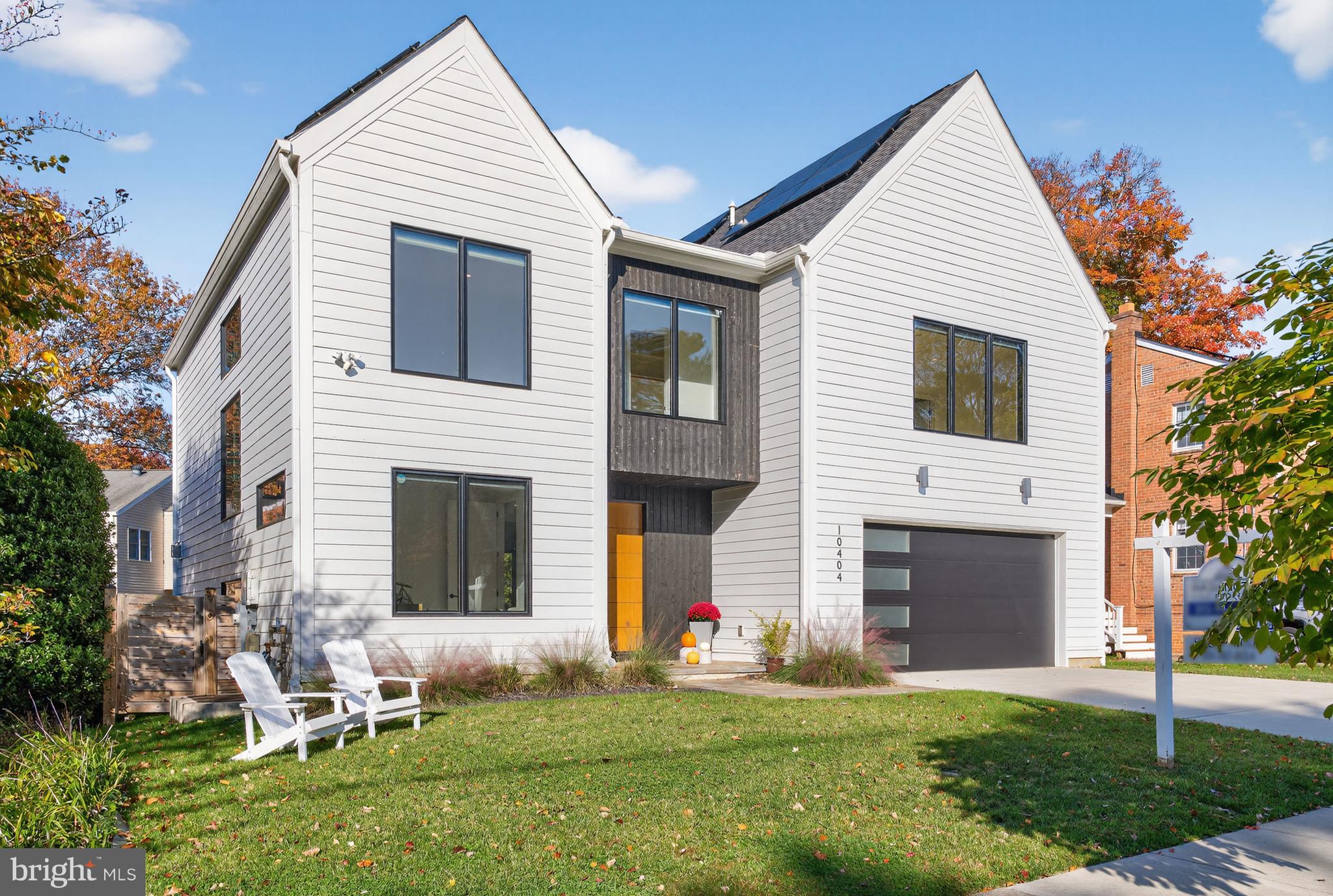 This pristine Scandinavian-inspired home is in a category of its own. Custom-built from the ground up and less than 4 years young, the finishes are superb. Crisp white Hardie lap siding converges with dramatic charred Yakisugi vertical siding at the covered main entrance. Environmentally and financially friendly, this home boasts a fully owned solar panel system. Exceptional features of the dazzling, sundrenched interior include solid white oak hardwood flooring, 9-foot ceilings on all three levels, large-scale Jeld-Wen windows and patio doors, custom shades, and a curated tile selection. Offering 5 bedrooms and 4.5 baths, the floor plan is open and efficient. Main level highlights include: 8-foot doors; a private office; a large living room with a charred cypress accent wall, discreet storage, and a 2-sided corner gas fireplace; an airy dining area with a sleek linear pendant light; a European dream kitchen with custom Marfa handleless cabinetry, an oversized contrasting center island, elegant quartz countertops and backsplash, Bosch stainless appliances, and a walk-in pantry; a mudroom with a built-in bench and cubbies against a shiplap wall; glass door access to the rear grounds. Flanked by a white oak slat wall and illuminated by oversized picture windows, the semi-open staircase ascends to the home’s upper level which offers a spacious primary retreat with an office alcove, 2 walk-in closets, and a gorgeous spa-like bathroom with a free-standing soaking tub, a curbless walk-in glass shower and double floating vanities. Two additional ample bedrooms, each with stylish ensuite bathrooms and walk-in closets, grace the front of the house. A phenomenal central family room and an adjacent laundry room complete the upper level. Providing wonderful overflow options and inviting space for guests, the daylit lower level offers a sizeable recreation room with a wet bar, two bedrooms each with walk-in closets, a full bath with a glass-enclosed shower and built-in bench, and a variety of storage options. Outside, a lovely flagstone terrace with a natural gas connection overlooks the large, lush fully fenced rear yard whereas a 2-car garage and concrete parking pad round out the front. Convenient to downtown Kensington, the Marc train, and two metro stations and in the Kensington-Parkwood/North Bethesda/Walter Johnson school zones, this location is ideal.
