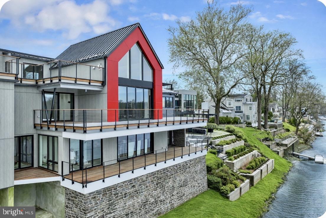 A singular riverfront offering — where architecture, atmosphere, and artistry converge.
Set along a prized stretch of the Delaware River in the heart of New Hope, this exceptional residence presents a refined expression of modern living , where daily life is shaped by light, water, and thoughtful design. Walls of glass and fully retractable sliders dissolve the boundary between indoors and out, framing unobstructed views of the river and the landscape beyond. A signature offering, built by Barley Custom Homes.
Mornings begin with coffee on the heated private terrace, as sunrise casts a soft glow across the water and natural light fills the home.
Spanning approximately 4450 square feet, the residence offers three beautifully appointed ensuite bedrooms, 4.5 baths, and a fully finished lower level designed as a seamless extension of the home , ideal for a private guest suite, wellness retreat, media lounge, or additional bedroom, thoughtfully tailored to a lifestyle defined by ease, intention, and understated sophistication.
The kitchen is both sculptural and functional, appointed with Wolf Sub-Zero appliances, an induction cooktop, luminous Crystallis surfaces, and custom cabinetry by Village Handcrafted with an artisan-crafted finish. A statement Crystallis bar opens seamlessly for entertaining, while rich hardwood flooring flows throughout.
The primary suite offers a private, spa-like retreat with a boutique-style walk-in closet, soaking tub, and a beautifully appointed walk-in shower.
Afternoons unfold on the water , launch from your private dock, glide along the Delaware by kayak or boat, and experience a level of riverfront living that is as rare as it is extraordinary. Evenings are best spent on the terrace, dining al fresco with views of the illuminated Lambertville Bridge reflecting across the water.
With direct garage entry, three dedicated parking spaces, and the rare advantage of exceptionally low taxes and a low HOA, ownership here is as considered as it is effortless.
Ideally positioned just steps from New Hope’s celebrated dining, boutiques, galleries, and theater, and within easy reach of Princeton, Philadelphia, and New York City, the residence offers a seamless balance of accessibility and retreat.