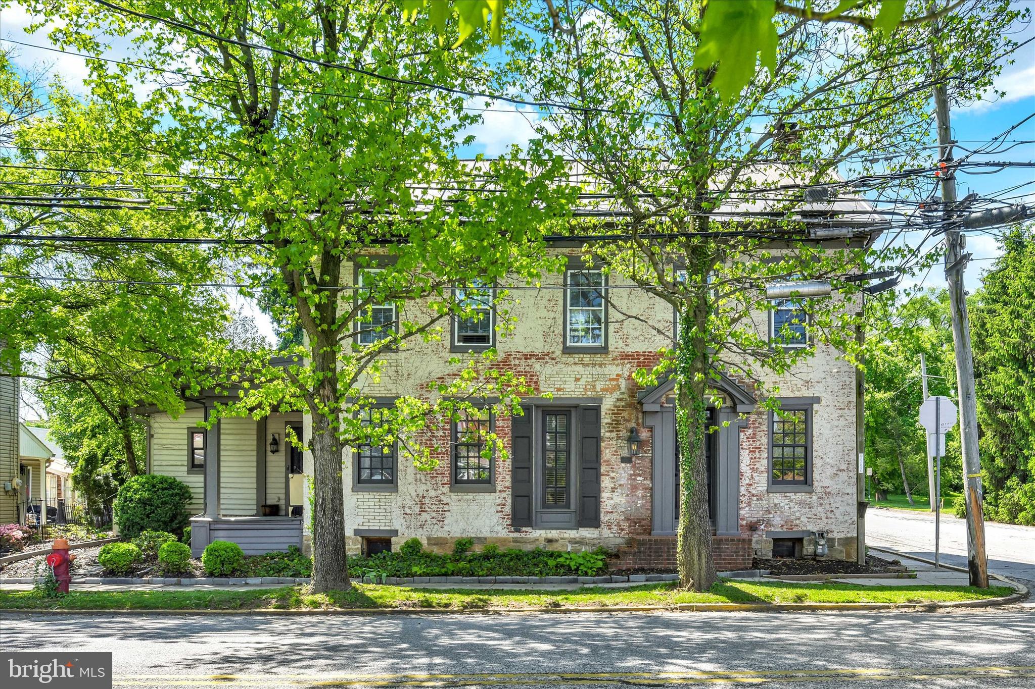 If you love character and quality construction, you will love this 5 bedroom, 4 full bath, 2700 sq. ft., circa 1858 triple-thick brick, metal roof home right in the heart of New Oxford, known for it antique stores and beautiful town square. High ceilings with exposed beams, exposed brick walls and floors recovered from a barn set the tone, along with wavy glass double-pane windows, exterior walnut trim work, Williamsburg-approved lights in foyer and stairs to attic, metal flooring thresholds, deep window sills, stone-front fireplace and crown moldings. Kitchen shines with granite countertops,  porcelain sink, beveled glass-front cabinet and a skylight.   Bathrooms feature Kohler and Delta fixtures, toilets and sinks.  Convenient 1st floor laundry room. The outside space is just as charming with wisteria covered arbor, beautiful landscaping, black aluminum fence and paver driveway.  House had once been used as a multi-unit rental, so there are kitchen hookups in one of the upstairs bedrooms as well as in the basement.  There are 2 additional fireplaces in the basement, but sellers have not attempted to use and the gas is capped.  Come take a look before it's gone!
