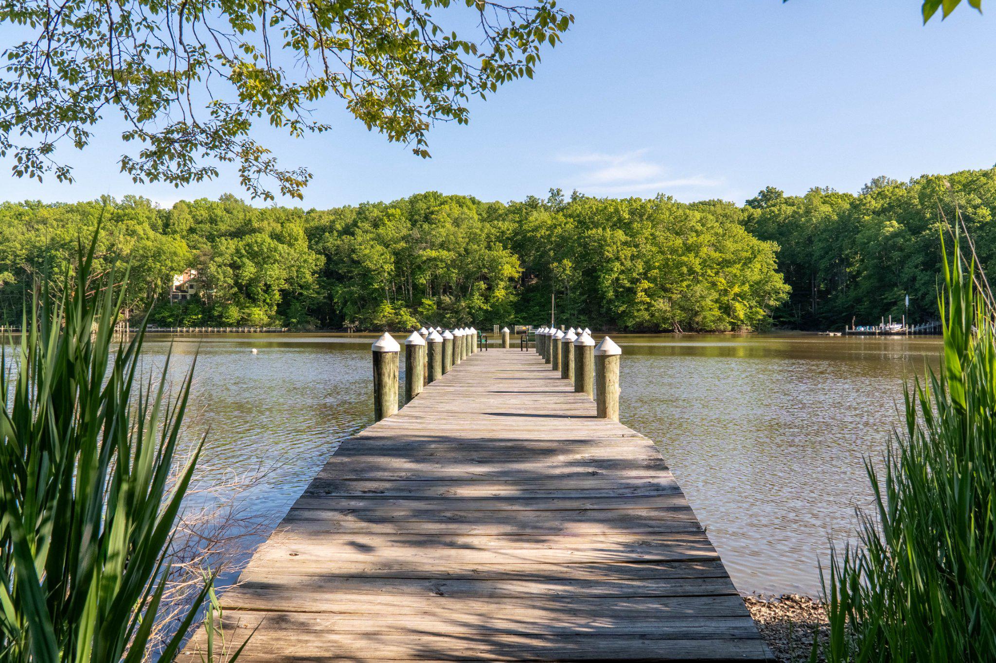 Welcome to easy living in Waterford — a water-privileged community on Beards Creek, just minutes from everything that makes life on the South River special. From here, Downtown Annapolis and West Street's varied dining and options are a short drive away. Local favorites like Mike's Crab House, right around the corner in Riva, offer classic Chesapeake waterfront dining. Annapolis Town Center and Festival at Riva offering Whole Foods, shops, and dining are very convenient. Spend a weekend exploring Quiet Waters Park's trails and playgrounds, paddle out from Triton Beach Park, or unwind at Mayo Beach Park with a sunset over the water. Commuters will appreciate easy access to Route 50, Annapolis, Washington DC, Baltimore, and Fort Meade and the Naval Academy , making this an ideal home base for work and play alike.

Waterford residents also enjoy community pier access to Beards Creek, leading out to the South River, plus kayak storage and launch, a neighborhood playground, and a wooded path perfect for an evening walk or morning run — all just steps from your door.

And the home itself delivers the same ease of living. This beautifully maintained townhome offers the rare combination today's buyer is searching for: a truly turnkey home and an unbeatable location. The major systems are already attended to — new HVAC (2025), new roof (2023), new sliders and storm door (2023), and a new oven (2025) — so there's nothing left to do but move in and start enjoying the lifestyle.

Inside, the open three-level layout lives large for a townhome, with vaulted ceilings, generous windows, and a flow that feels more like a single-family home than a row of attached units. The main level brings everyone together with a spacious family room, open kitchen, and dining area, all connected by a breakfast bar made for easy mornings and easier entertaining. Step through the rear slider to the expansive deck — host friends for dinner under the trees, or simply enjoy a quiet evening. Upstairs, the primary suite is a genuine retreat, with treetop views and a skylight-brightened en-suite bath that fills the room with natural light. Two additional bedrooms offer the flexibility today's households need — guest rooms, a home office, or space to grow into. Downstairs, the finished lower level adds even more versatility: a home gym, media room, playroom, or office, with direct walkout access to the covered patio below.
Homes that offer this kind of water-privileged community access, proximity to Annapolis's best dining and recreation, and move-in-ready condition rarely stay available for long. Schedule your private tour of 1369 Escapade Ct today and experience the Waterford lifestyle for yourself.