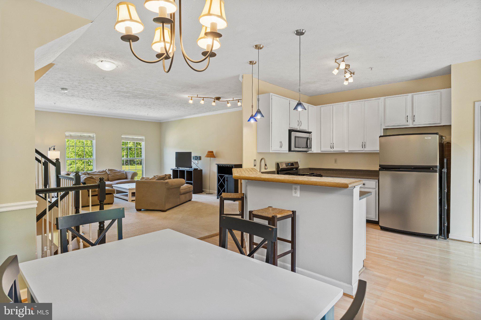 Truly turnkey, with no major systems to worry about for years. This home in the water-privileged Waterford community was completely refreshed where it counts: new HVAC (2025), new roof (2023), new sliders and storm door (2023), and a new oven (2025). That means the big-ticket items are already done. What's left is simply moving in and enjoying the lifestyle.

And that lifestyle is hard to beat. Set against a lush, tree-lined backdrop, 1369 Escapade Ct offers the kind of setting that instantly shifts the pace. Morning coffee on the expansive rear deck. Dinner with the doors open to the breeze. Quiet evenings under the covered patio below, wrapped in greenery and seasonal color. With a wooded path just beyond the back door, the connection to the outdoors feels effortless and immediate.

Inside, the three-level layout feels open, inviting, and easy to live in. Vaulted ceilings add volume to the main living spaces, while generous windows draw in beautiful natural light and frame the surrounding greenery. The main level brings everyone together with a spacious family room, open kitchen, and dining area that flow naturally from one space to the next. The breakfast bar creates a welcoming place to gather, and the rear sliders extend everyday living out to the deck for a seamless indoor-outdoor rhythm.
Upstairs, the primary bedroom offers a calming retreat with treetop views, and the primary bath is brightened by a skylight that adds an unexpected layer of warmth and natural light. The additional bedrooms provide flexibility for guests, work, or daily routines. The finished lower level adds even more versatile space for movies, workouts, hobbies, or a home office, with direct access to the covered outdoor area.

Beyond the home itself, Waterford is a water-privileged community offering a neighborhood playground, community pier access to Beards Creek connecting to the South River, kayak storage rental, and a wooded path right out back for exercise and dog walking. All of it is conveniently located near shopping, restaurants, recreation, Annapolis, Washington, Baltimore, and Fort Meade. A move-in-ready home and a water-access lifestyle, all in one — come see it for yourself.
