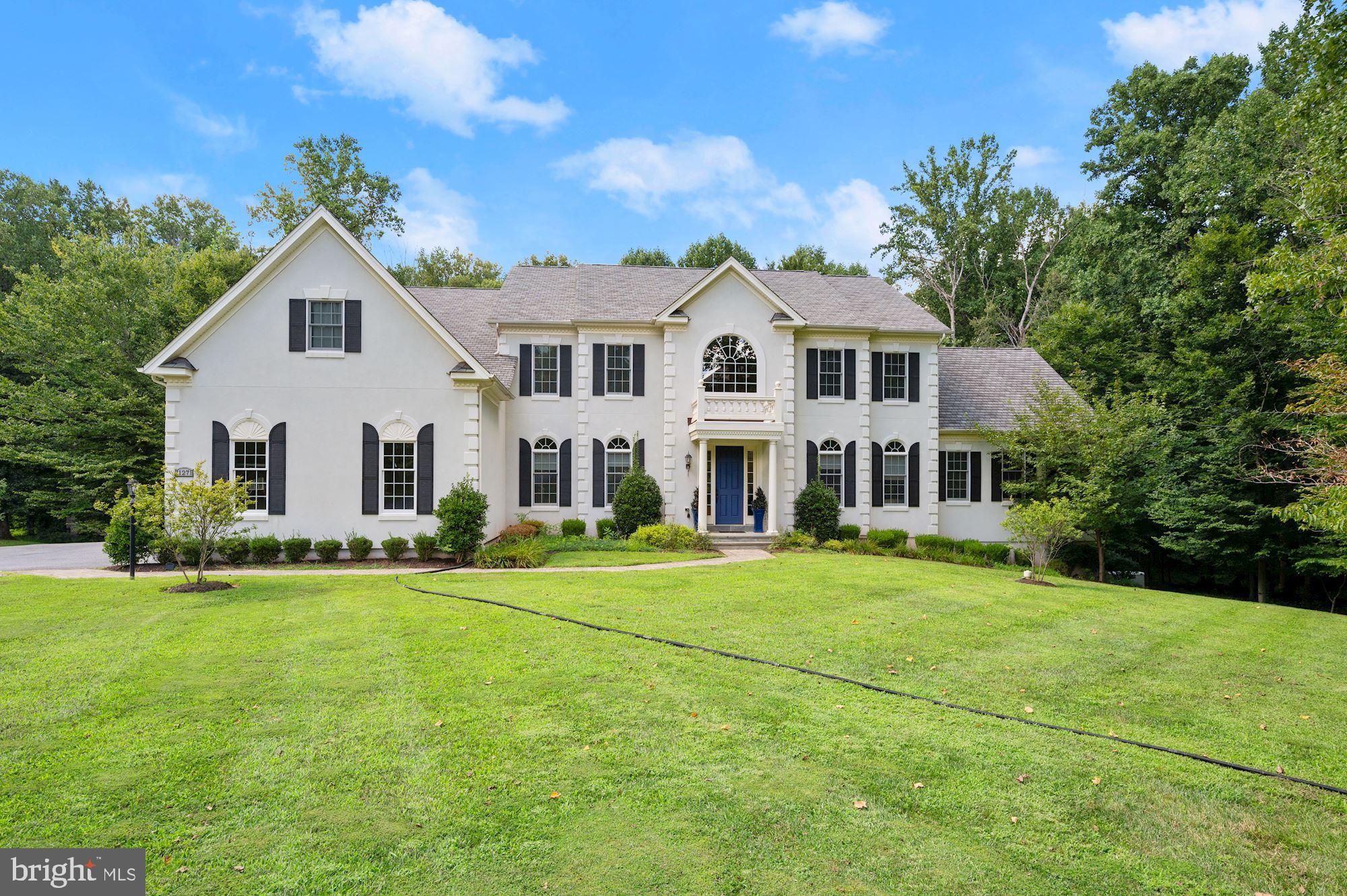 This immaculate residence has extraordinary upgrades and backs to parkland offering a perfect setting for living and entertaining. Welcome guests with a brick herringbone pattern walk, a rectangular portico, and a covered slate porch.  Inside, arrival is celebrated with a grand two-story foyer, and two sweeping curved staircases, embellished with iron balusters.  This quintessential Henley model, designed and built by Toll Brothers offers a formal living room and formal dining room with tray ceilings flanking the elegant marble foyer, while an extended foyer is punctuated with four columns and unfolds to a two-story great room with a dramatic coffered two-story ceiling. Outstanding features and upgrades also include a stunning gas fireplace with mantle, over-mantle molding detail, and a secondary back stair. 
The hallmark chef’s kitchen is at the heart of the home and has adjacencies accessing the great room, dining room; butlers service pantry, breakfast room, morning room, and outdoor dining deck.   The kitchen is outfitted with richly finished hardwood floors, 42” cabinetry, granite counters, a gas cook station, and a gracious walk-pantry.  Gatherings large and small will be well served around a commanding center entertainer’s island with three pendants, and, an expansive peninsula breakfast bar that transitions seamlessly to the adjacent morning room and breakfast room.
Upstairs, an elegant open landing is embellished with iron balusters overlooking the foyer and the great room. The dramatic upper landing is encircled by three additional en-suite bedrooms; each has a private attached full bath and can be accessed from one of three stairs.  Luxury living is fully expressed in the Owner's Suite with French doors opening into a spacious den and sitting room, followed by paired columns that open to the suite bedroom.   Deep tray ceilings accent the bedroom area while the second pair of French doors open to a sumptuous spa-like bath, featuring separate vanities, a soaking tub, a walk-in shower, and gorgeous accent tile.  Two dressing closets complete the Owner’s suite: a large walk-in dressing closet in the bedroom, and a second, hallmark bonus walk-in dressing closet in the suite bath boasting more than enough space for the most extensive wardrobe and shoe collection. Downstairs, a guest suite with a private den and a full bath opens to the adjacent recreation room where light streams in from full daylight windows and a walk-out door to the private rear lawn.