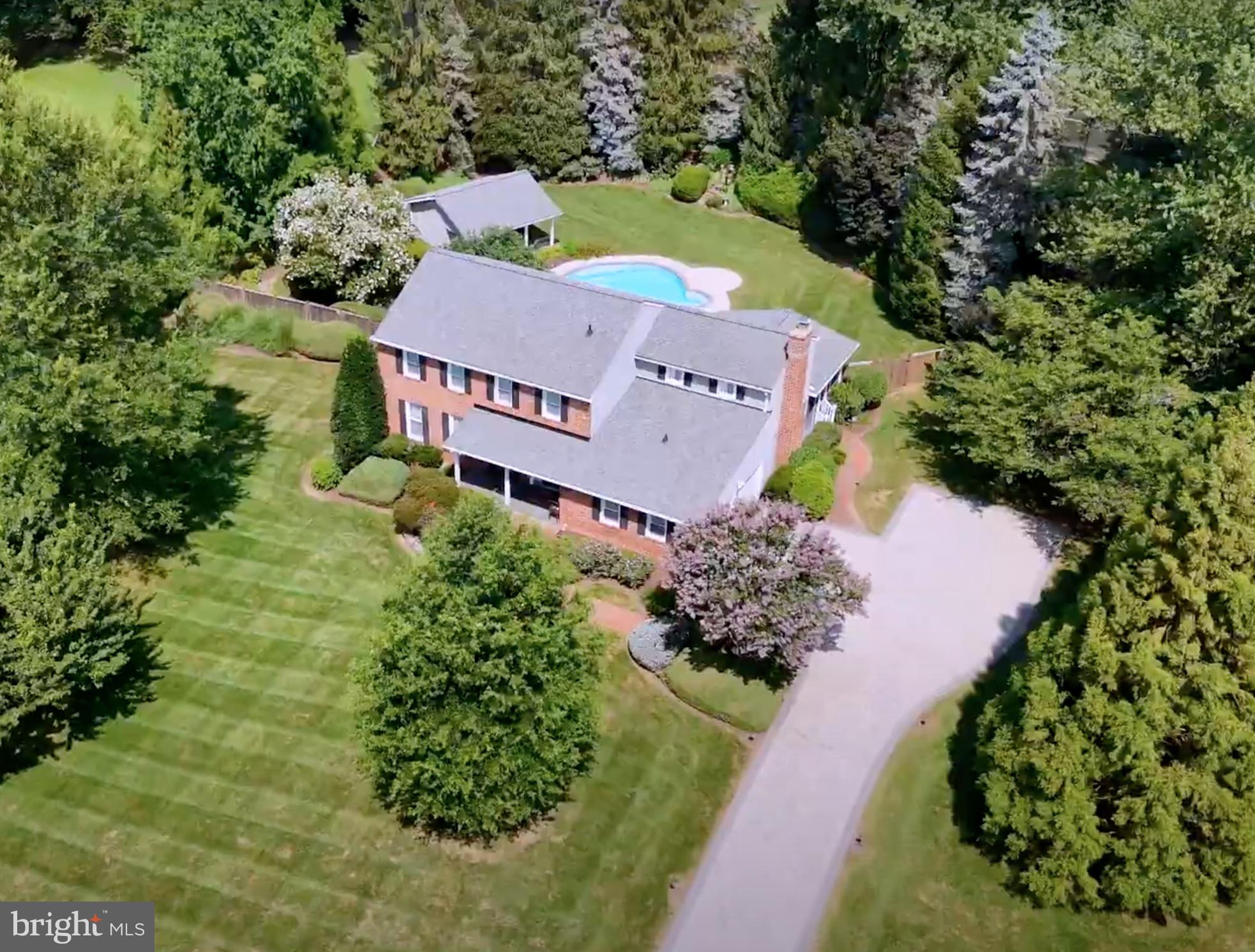 Elegant brick-front colonial home set on over two private acres in sought-after Equestrian Park. Tucked away on a quiet cul-de-sac, this exceptional residence offers rare privacy, resort-style outdoor living, and refined interior spaces just minutes from Metro, major commuter routes, and Dulles Airport.
A picturesque stone driveway leads to the home, where manicured grounds unfold into an extraordinary outdoor setting. The expansive fenced backyard is designed for both relaxation and entertaining, featuring a heated in-ground pool, a cabana/pool house, and a large, screened porch overlooking the grounds. Beyond the main yard lies a separate recreation area with private tennis and pickleball courts, tennis house with viewing porch, and an open lawn, creating a truly unique estate-like retreat.

Inside, timeless architectural details and quality finishes define the home, including hardwood floors, crown moldings, plantation shutters, and Roman shades throughout. The gourmet kitchen is thoughtfully designed for both everyday living and entertaining, anchored by a large granite island with seating and appointed with stainless steel appliances, including a Professional Service Thermador Triple Oven with warming drawer, standard oven, and microwave, a Thermador six-burner cooktop with pot filler, Zephyr chef’s hood, wine refrigerator, slate backsplash, and under-cabinet lighting. A formal dining room sits just off the kitchen for elegant gatherings. The family room with raised brick hearth fireplace opens through French doors to the screened porch, seamlessly connecting indoor and outdoor living. Additional main level spaces include a formal living room and generous family gathering areas. The luxurious primary suite offers a private sitting room and a beautifully renovated spa bath featuring floor-to-ceiling tile, double vanity, walk-in shower, and custom walk-in closet with built-ins. The finished lower level provides exceptional flexibility with a large recreation room, separate den/workroom, and a third full bath, ideal for entertaining, guests, or home office use.

The home also features Lutron smart lighting, double-pane storm windows, and Schlage electonic locks on doors with remote monitoring. Extensive system upgrades include new HVAC (2024) with steam humidifier, Air Knight air purification system, and remote Carrier system management app, 105 gallon Rheem Marathon hot water heater, and new roof (under 2 years). Propane tank for the pool heater is under 2 years old. Remote programmable management capability for in-ground Rainbird Sprinkler system. Verizon FIOS and Cox Internet are available.  A rare opportunity to own a private luxury retreat on over two acres in one of Fairfax County’s most desirable communities.