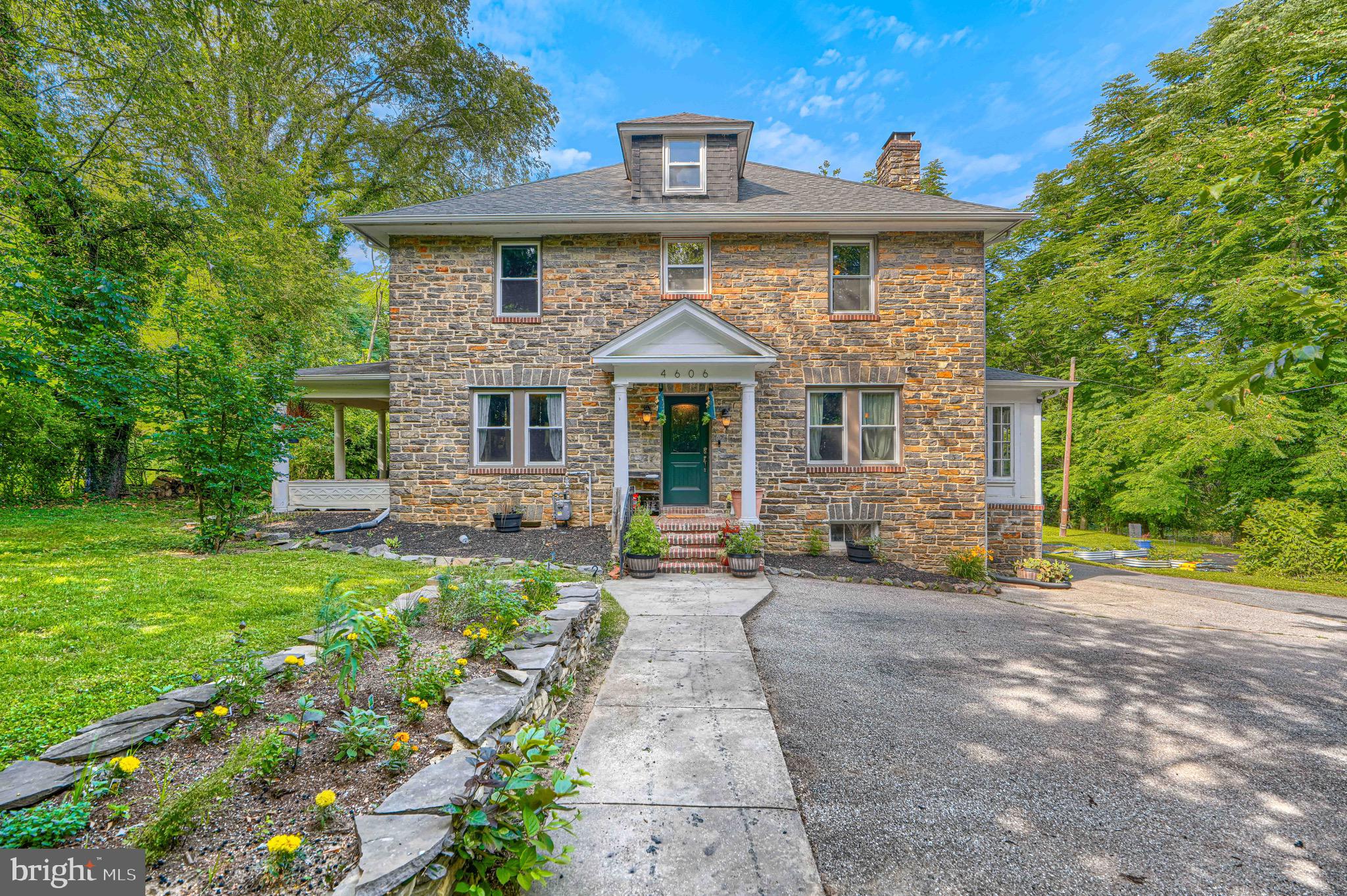 Tucked away on a quiet street in Baltimore City's Yale Heights neighborhood, this impressive stone residence offers over 4,000 square feet of total living space on a rare 0.44-acre lot. The home is currently configured as a spacious 4-bedroom residence featuring an oversized owner's suite walk-in closet that can easily be converted back into a 5th bedroom if desired. Inside, you'll find timeless hardwood floors, a cozy wood-burning fireplace and a bright sunroom. Recent improvements include new energy efficient windows and a fully updated electric breaker panel. Additional improvements include a tankless water heater and a professionally waterproofed basement, offering plenty of space for additional recreational. Just off the kitchen and family room, a covered side porch provides the perfect space for grilling, outdoor dining, and relaxing in the shade during warmer months, creating a seamless connection between indoor and outdoor living. The outdoor setting is equally exceptional. The expansive, flat, cleared, and fully fenced backyard provides endless possibilities for recreation, gardening, entertaining, or simply enjoying your own private green space—a rare find within Baltimore City. Offering a unique combination of space, privacy, character, and flexibility, this hidden gem delivers the best of both worlds: a peaceful residential setting with convenient access to everything Baltimore has to offer.