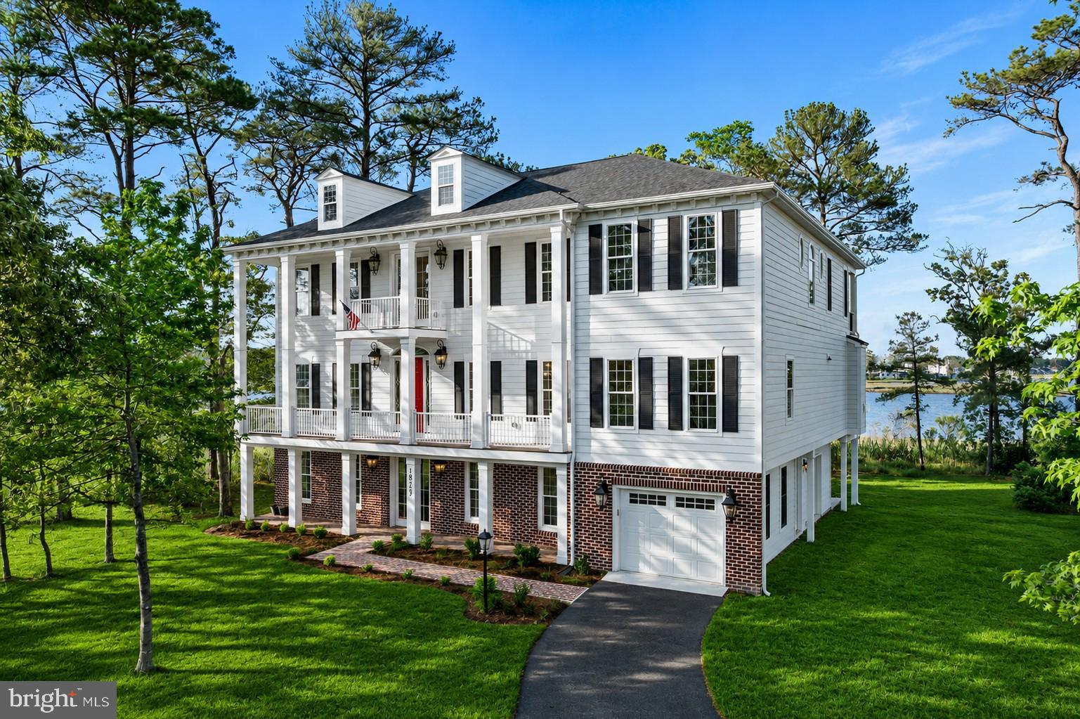 As you wind down the scenic drive to this stunning 6-bedroom Charleston-inspired
estate, you’ll immediately feel a sense of warmth, serenity, and gratitude. Thoughtfully
designed with exceptional attention to detail — including a dedicated side-entry garage
for your golf cart — this remarkable home embraces luxury at every turn. Expansive
water and skyline views stretch throughout the property, while the sellers have carefully
enhanced the natural surroundings to maximize both beauty and privacy.

Designed to showcase breathtaking views toward the OCMD skyline, the main living
level features a spectacular great room with walls of windows and seamless access to
the rear balcony from both the breakfast area and sitting room — the perfect setting for
morning coffee or unforgettable sunsets.

The second level is an entertainer’s dream, offering three fireplaces, a gourmet chef’s
kitchen, a spacious breakfast area, an elegant dining room, an oversized music room,
and an inviting great room designed for gathering and relaxing alike.

The first floor offers incredible flexibility with a private in-law or student suite complete
with its own fully functional kitchen, sitting room with a fireplace, two bedrooms, and a
full bath — ideal for extended family, guests, or multigenerational living.
The upper bedroom level features four spacious bedrooms, including a luxurious
owner’s suite retreat. Two bedrooms are connected by a Jack-and-Jill bath, while the
third enjoys its own private ensuite. The owner’s suite offers a private balcony, a
fireplace for cold fall evenings, dual oversized walk-in closets, and a beautifully
appointed spa-like bath.

While words can only begin to capture the thoughtful floor plan and upscale finishes
throughout, this extraordinary residence must truly be experienced in person.
Schedule your private tour today and see you shortly