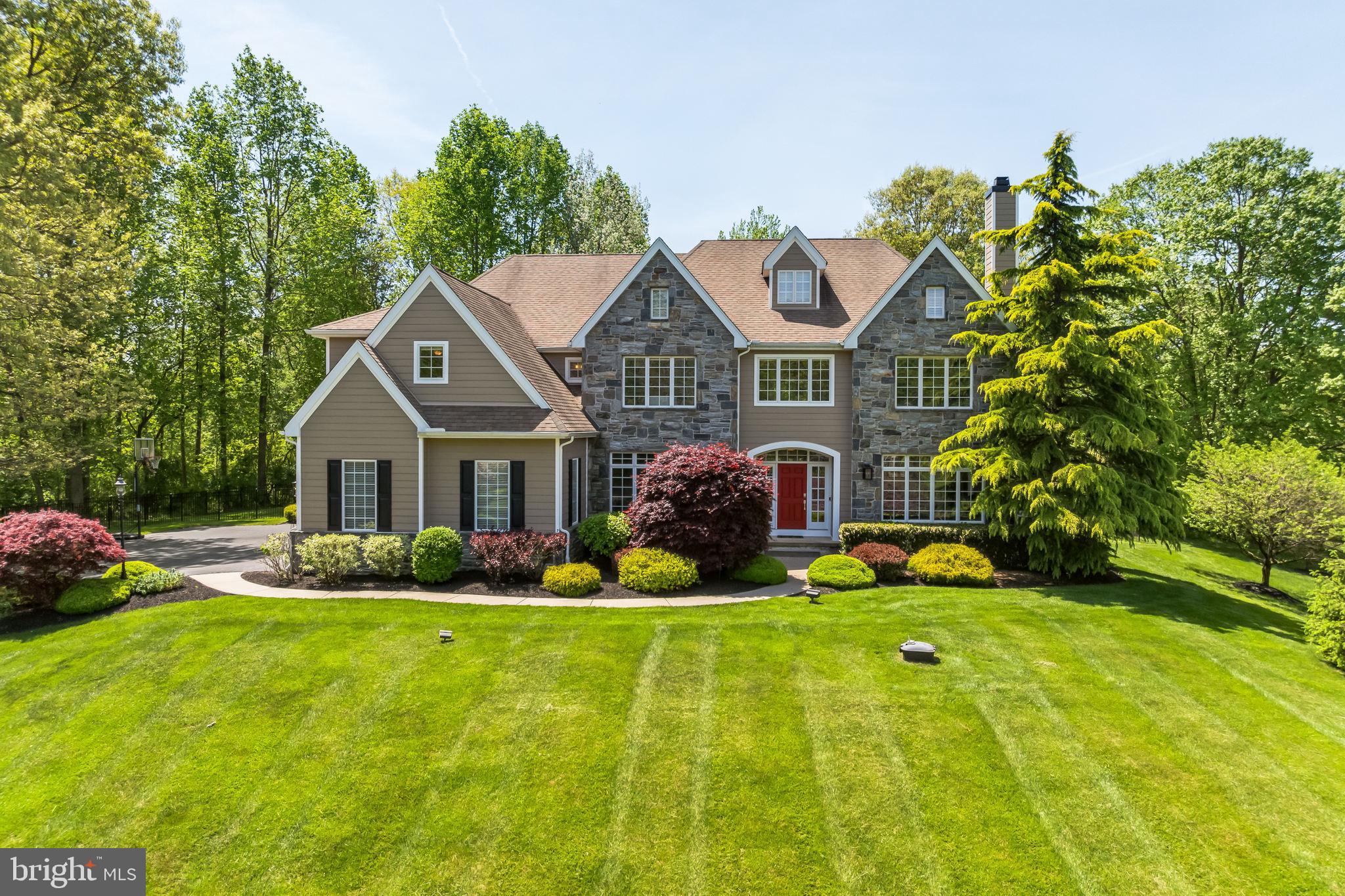 Welcome home to 1115 Oak Hollow Drive in West Bradford Township, situated on a premier cul-de-sac lot in the highly coveted community of Oak Hollow. This beautifully updated and spacious property offers the best in Chester County living within the exceptionally regarded Downingtown Area School District.  Originally designed by Ann Capron and built by Megill Homes, the five bedroom, three and one half baths home encompasses nearly 5000 SF of living space with an additional 2,000 sq ft finished basement. These spaces have been highly customized and recently updated. The Windsor model home embraces the best of traditional quality and details while capitalizing on a modern open plan with soaring 9’ ceilings and abundant natural light. Enter into a central foyer which opens to a formal dining room on the left, and the living room on the right with a wood burning fireplace. The thoughtful, upscale details in these spaces including wainscotting, crown molding, hardwood floors throughout and arched openings set the tone for the entire property. Adjacent to the dining room is a gourmet kitchen which serves as the hub of the home. A large island with seating offset with two-toned cabinets, double wall ovens, a wine fridge, abundant wood cabinetry are a few of the special features. The spacious breakfast room with sliders to the patio and the enlarged great room with stone fireplace and vaulted ceilings with are both open to the kitchen. On the opposite side of the first floor, are a home office, a half bath, and a solarium which is an ideal for either a second home office, playroom or gathering space. Outside, running along the back of all of these spaces is an incredible paver patio with distinct areas for a fire pit, dining, lounging, and gathering, as well as relaxing in the newer hot tub, all while overlooking the lush and level fenced back yard. On the upper level of the home, the primary suite is truly special. With a sitting area, a walk-in closet, a lavish dressing room/closet and en-suite bathroom you will find a peaceful oasis made for true relaxation. The private en-suite bath offers a soaking tub as well as a marble walk-in shower, dual vanities and separate WC. The fifth bedroom has been converted to a custom dressing room with an incredible built-in closet system complete with granite countertops...yet this can easily be returned to a 5th bedroom. The upper level also incorporates three additional generously sized bedrooms, a “jack and jill” style bathroom and a hall bath. Down the hall is the laundry room and a wonderful study nook. The lower level of the home is finished to contribute nearly 2000 sf of living space, has a walk up exit to the side yard and plenty of storage. Other amenities include an attached three car garage with car lift, a whole house generator, and a Hardi-plank and stone exterior.  The current owners meticulously maintained and improved the home during their ownership: Hardi-plank installed in 2023, a new HVAC system 2022 and professional painting throughout in 2024.  Superbly located in Chester County, the community offers close proximities to Downingtown and West Chester Boroughs, train lines, commuter routes, and major employment and retail centers.