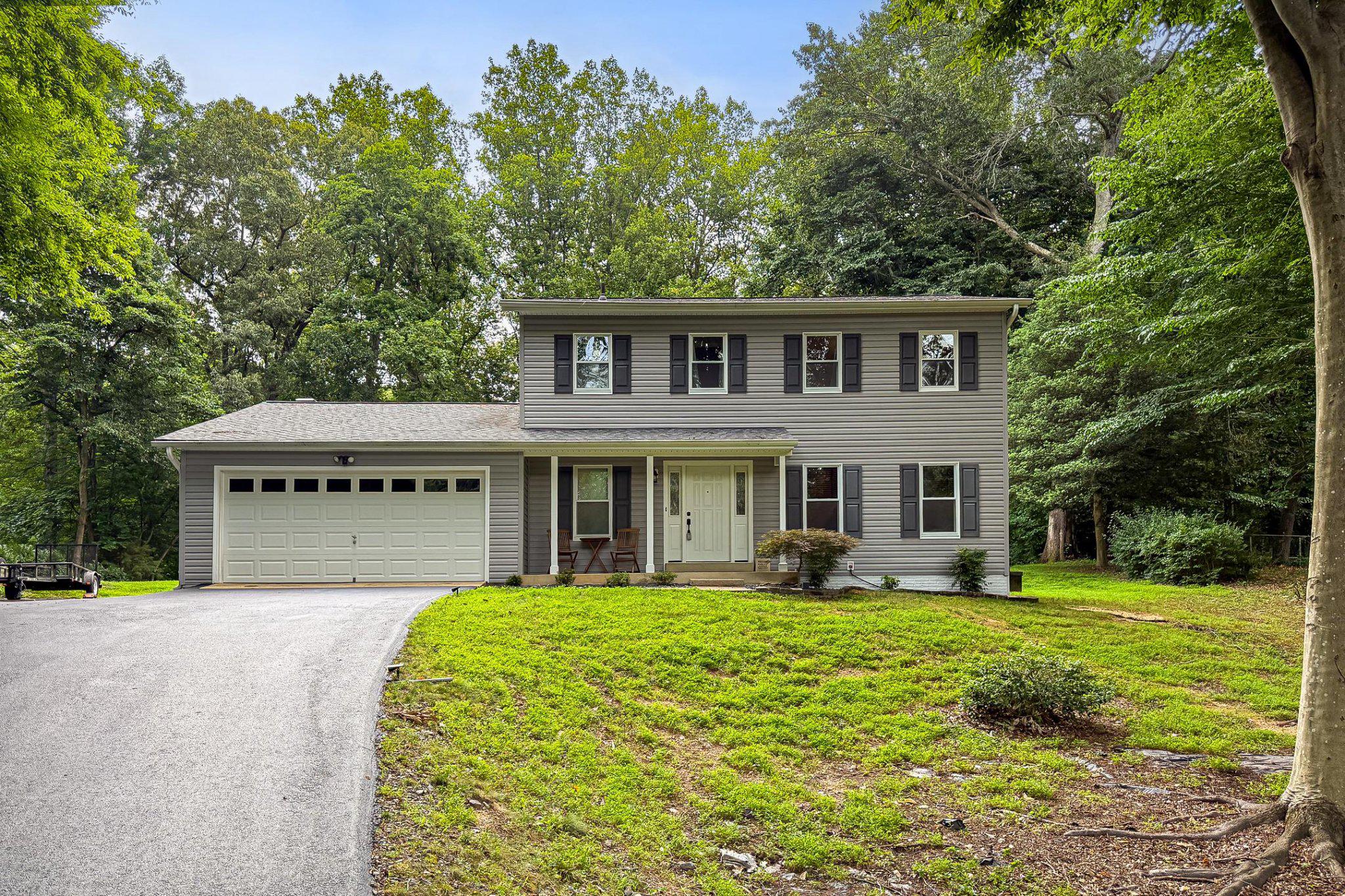Set on a private, tree-lined 1.02-acre lot, this 4-bedroom, 2.5-bath colonial offers classic character and move-in-ready comfort. Hardwood floors run through the living and dining rooms, while the family room features a cozy wood-burning fireplace. The updated kitchen and a sunny breakfast area make everyday living easy, and main-level laundry adds convenience.
Upstairs, the primary suite includes a walk-in closet and a beautifully updated bath with tiled shower and spa-toned flooring. Three additional bedrooms �� all with new carpet — share an updated hall bath with designer tile.
Outside, a spacious paver patio overlooks a level, wooded backyard, perfect for entertaining or quiet relaxation. A newly paved driveway completes the curb appeal.
With over $56,000 in recent upgrades — including a new roof (2020), updated kitchen (2023), fresh paint and carpet (2026), regrouted baths, and a serviced HVAC system — this home offers peace of mind along with its peaceful setting.
Conveniently located near Prince William Parkway, I-95, VRE, and close to Lake Manassas and Fountainhead Regional Park, this home blends country charm with everyday convenience. Welcome Home!