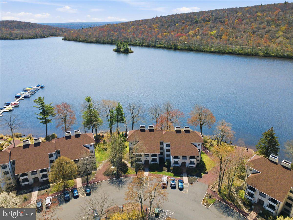 Lakefront, First-Floor, Turnkey, Beautiful Views!--It Doesn't Get Better Than This! Unbeatable Midlakes location with jaw-dropping lake views--so close you can practically touch the water. Enjoy year-round scenery, including Big Boulder Ski Area lit up all winter long. Prime location in the community! First-floor unit = walk right off of your patio to the lake. Inside features spacious rooms, newer ductless A/C + heat, a cozy wood-burning fireplace, Jacuzzi bath tub, and newer windows including a picture window for uninterrupted lake views. Sold fully furnished and completely turnkey--includes all appliances, washer/dryer, TVs, and more. Midlakes offers a community pool + hot tub, plus optional access to Boulder Lake Club with beach, heated pool, tennis, volleyball, boat/kayak rentals, and tons of activities. Condo fee covers water, sewer, trash & grounds maintenance! Perfect as a getaway, investment, or both.
