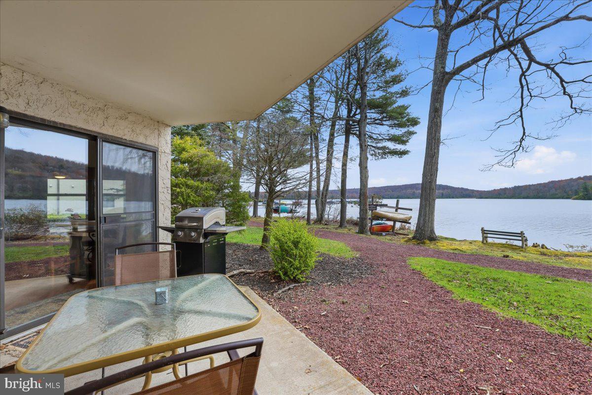 Lakefront, First-Floor, Turnkey, Beautiful Views!--It Doesn't Get Better Than This! Unbeatable Midlakes location with jaw-dropping lake views--so close you can practically touch the water. Enjoy year-round scenery, including Big Boulder Ski Area lit up all winter long. Prime location in the community! First-floor unit = walk right off of your patio to the lake. Inside features spacious rooms, newer ductless A/C + heat, a cozy wood-burning fireplace, Jacuzzi bath tub, and newer windows including a picture window for uninterrupted lake views. Sold fully furnished and completely turnkey--includes all appliances, washer/dryer, TVs, and more. Midlakes offers a community pool + hot tub, plus optional access to Boulder Lake Club with beach, heated pool, tennis, volleyball, boat/kayak rentals, and tons of activities. Condo fee covers water, sewer, trash & grounds maintenance! Perfect as a getaway, investment, or both.