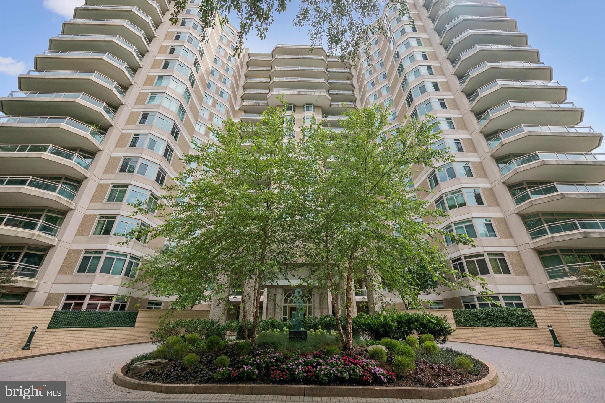 Resort-Style Living in the heart of Chevy Chase. Welcome to Parc Somerset (the newest of the 3 buildings), the crown jewel of luxury condominium living in Friendship Heights. This well-maintained two-bedroom + den, two-bath residence offers an unmatched blend of elegance, comfort, and lifestyle—all within the area’s most exclusive gated community spanning 17+ beautifully landscaped acres. Step into a grand, light-filled interior featuring gleaming hardwood floors and gracious proportions throughout. The expansive living and dining area is anchored by a gas fireplace with marble surround - perfect for entertaining or quiet evenings at home. Walls of glass windows and door open to an impressive wraparound balcony with sweeping views of lush greenery and tennis courts, seamlessly connecting indoor and outdoor living. The kitchen features a charming bay window breakfast area, stainless steel appliances and a built-in pantry with direct access to the balcony—ideal for morning coffee or al fresco dining. A separate den provides the perfect setting for a home office or cozy retreat. The luxurious primary suite is a private sanctuary with plush carpeting (hardwood  flooring underneath), a spacious walk-in closet, and a spa-inspired en-suite bath complete with a jetted soaking tub, glass-enclosed shower, and dual vanities.  An additional bedroom and bathroom flank the laundry room with sink & cabinets. Additional features include THREE premium indoor parking spaces and a large private storage unit. Residents of Parc Somerset enjoy 24-hour concierge and valet service, on-site gatehouse security, and access to a world-class, three-level clubhouse. Amenities include indoor and outdoor swimming pools, state-of-the-art fitness center, aerobics studio, tennis and racquetball courts, billiards and ping pong rooms, and elegant party spaces. Located just moments from Metro, fine dining, high-end shopping, and premier medical centers, this is luxury living redefined. Unit comes with 3 parking spots and large storage space.