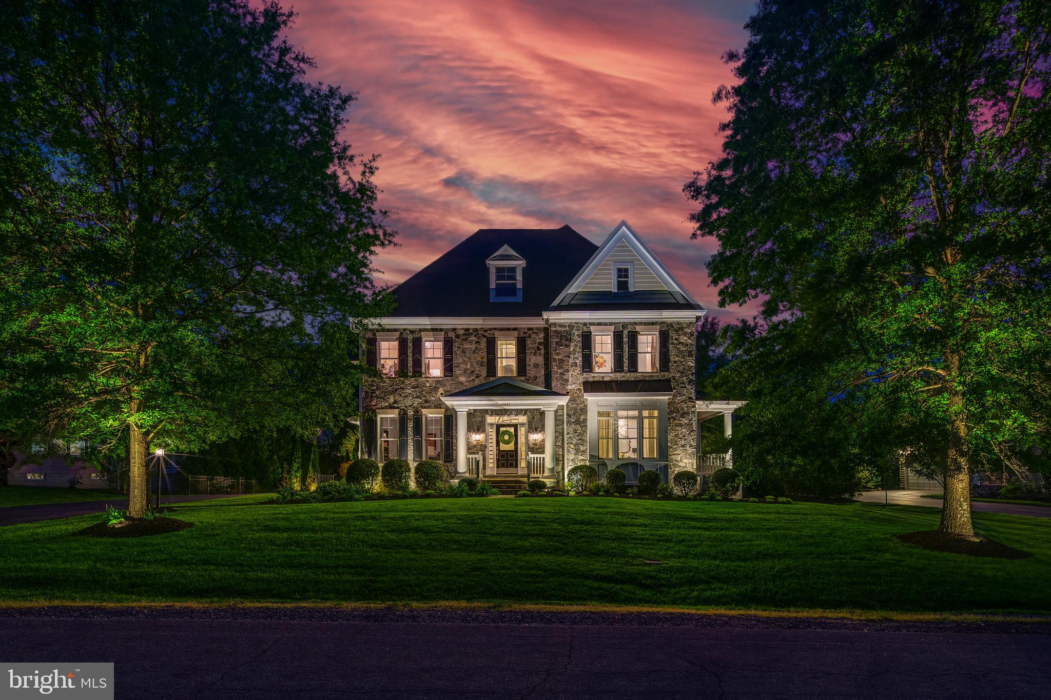 Welcome to this showstopping luxury estate home in the highly sought-after Village of Waxpool, offering over 7,100 square feet of refined living space across three impeccable finished levels. Perfectly sited on a premium half-acre lot backing to mature trees, this home seamlessly combines timeless elegance with modern luxury and walkable to top-rated Mill Run Elementary and Eagle Ridge Middle School.
Behind its stately curb appeal lies a breathtaking private backyard oasis— your own personal resort.  Boasting one of the most luxurious private pool house retreats imaginable—fully enclosed, climate-controlled, and designed for year-round entertaining—featuring a smartphone-controlled sparkling pool and spa, a 475 sq ft four season pool house with a half bath, a fully outfitted outdoor kitchen, and lush, professionally designed landscaping. It’s both an entertainer’s dream and a serene retreat.
At the heart of the home, the gourmet kitchen is a chef’s dream—thoughtfully appointed with top-tier custom cabinetry, designer fixtures, and professional-grade appliances including a premium Wolf cooktop. Luxury honed marble countertops and an expansive center island provide both style and function, while a generous walk-in pantry ensures optimal storage. The kitchen opens seamlessly to the inviting family room, where custom built-ins frame a striking fireplace enhanced with upgraded tile, quartz surround, and a custom wood mantle.
Rich hardwood floors span the main level, complemented by intricate trim and elegant moldings that elevate the home’s sophisticated character. The expansive layout includes formal living and dining rooms, a private study, and a sunroom extension that floods the home with natural light.
Upstairs, the luxurious owner’s suite offers a peaceful escape with a spacious bedroom, sitting area, three custom walk-in closets, and a spa-inspired en-suite bath featuring a frameless glass shower, whirlpool tub, and dual vanities. Three additional generously sized bedrooms offer privacy and comfort—all with walk-in closets. The bedroom-level laundry room is discreetly tucked behind a barn door for refined convenience.
The walk-up lower level is designed for recreation and relaxation with durable LVP flooring, a large recreation room, a custom bar with rich cabinetry and beverage storage, and a mirrored fitness room ideal for workouts or yoga. A private guest suite with a full bath and an oversized storage room complete the lower level.
Step outside to over $800,000 in outdoor enhancements. The resort-style pool and integrated spa are surrounded by an expansive deck and lush landscaping. The climate-controlled pool house offers year-round functionality with a full bath, dual mini-split systems, WiFi, surround sound, and a full-service buffet. Adjacent is a premium outdoor kitchen built for effortless entertaining. The upgraded lighting package enhances both ambiance and functionality throughout the grounds.
Completing this exceptional home is a side-load three-car garage with ample space for vehicles and storage, plus a built-in Tesla charger—perfect for today’s modern and eco-conscious lifestyle.  **Assumable VA Loan at 2.75% interest rate**