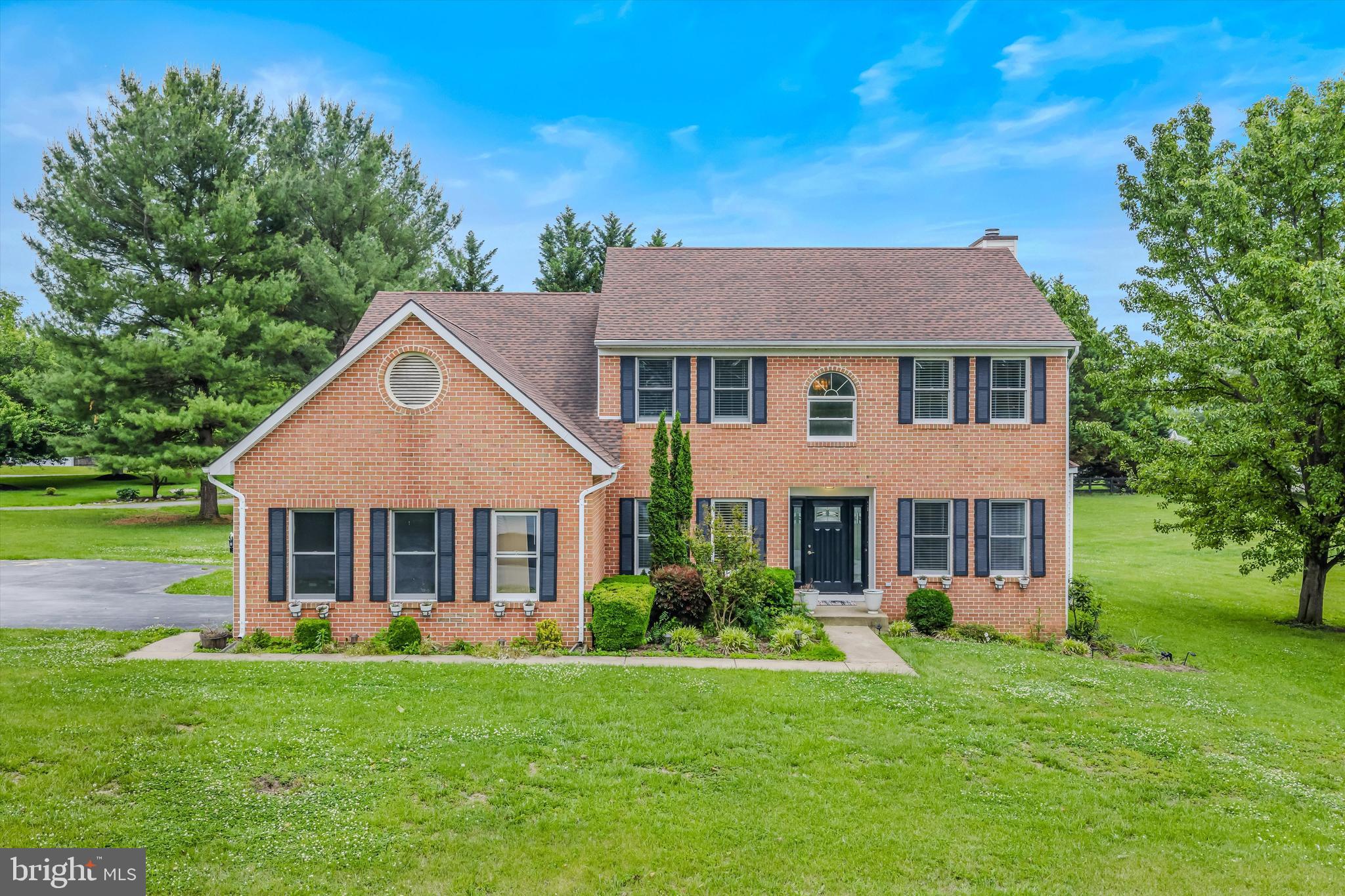 This stunning colonial offers 5 bedrooms and now 4 full baths, set on a beautiful, level 1.05-acre lot in sought-after Harpers Ferry. The home welcomes you with a grand two-story foyer featuring tile flooring, soaring ceilings, and an arched window. The main level includes a formal living room with hardwood floors and a bay window, a formal dining room with chair rail and picture molding, and a spacious family room highlighted by hardwood floors, chair rail, a wood-burning fireplace with raised hearth, and access to the expansive deck. The kitchen features tile floors, white cabinetry, granite countertops, updated black appliances, and a breakfast nook with bay window detail. A main-level bedroom and full bath add flexibility. Upstairs, the primary suite offers three closets and a private bath with an oversized double vanity, walk-in shower, soaking tub, and linen storage, while three additional bedrooms and a full hall bath complete the upper level. The lower level has been newly finished to include a large rec room and a full bath, providing excellent additional living space, along with laundry and storage. Outdoor living shines with a massive two-level deck overlooking mature trees, flower beds, and the expansive, lush backyard. With generous indoor space, outdoor privacy, and thoughtful updates, this home offers comfort, functionality, and room to grow in a beautiful Harpers Ferry setting.