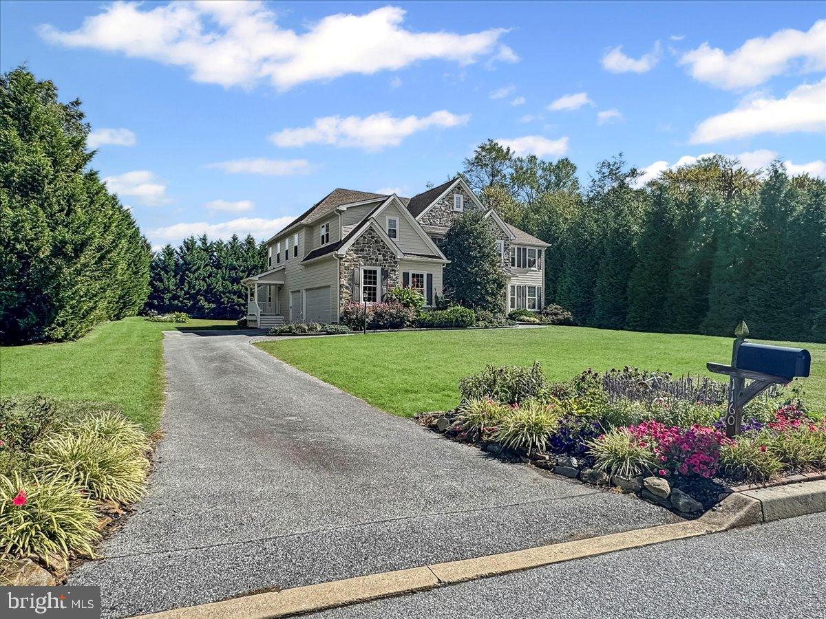Spectacular Pondview center hall Colonial; former model home nestled on a premium .7 acre private, level lot; one of the deepest most functional lots in the community featuring a lovely tree lined backyard for privacy, with lots of lush landscaping and beautiful gardens; perfect for large gatherings or a pool if desired, situated in the heart of Garnet Valley and top rated Garnet Valley schools.  A beautiful updated paver front walkway and raised flower bed flank a grand stone facade and James Hardie Plank exterior, with a charming portico that greets you at the main front entrance.  As you walk into a breathtaking entrance hall with a beautiful turned staircase, you're greeted by endless upgrades & high quality finishes including custom millwork, gleaming Brazilian Cherry wood floors that flow throughout the main level of a lovely open floor plan, 10' ceilings and much more. Only available due to downsizing, this fabulous upgraded & lovingly maintained home has 5 spacious bedrooms with ceiling fans on the upper level plus 3 full baths and lots of spacious closet space. The luxurious master suite is exceptionally grand & spacious; featuring a tray ceiling, crown moulding, a large sitting area, two walk-in closets, and a fabulous updated tiled en-suite master bath with a large soaking tub, an oversized walk in rainfall shower, his & her vanities and a separate water closet.  For added convenience, the laundry room is also situated on the upper level. The main level living area features a spacious family room with a cozy fireplace, new carpet (2024), a breezy ceiling fan, and added crown moulding, ceiling moulding & decorative beams; and is adjacent to the gourmet kitchen that has lots of beautiful high end 42" cabinetry, an oversized center island, a convenient pantry, stainless appliances including double ovens, dishwasher, cooktop, range hood and french-door refrigerator, lovely granite counters and a beautiful sunny morning room featuring a vaulted ceiling with crown and ceiling moulding, that walks out to a fantastic enclosed screened rear porch addition (added in 2014) with skylights and an expanded & updated rear Trex deck looking out over the tranquil, private, deep rear yard flanked by trees and lots of lush gardens.  Also adjacent to the kitchen is a grand formal dining room with crown moulding and chair rail.  Across the center hall from the dining room is a large living room with crown moulding, and there is a spacious private office, as well as a conveniently situated half bath with an updated vanity.  Also off the kitchen is a side hallway that leads to a spacious garage for three cars and all your toys, and a side entrance with an updated porch that has an enlarged roof, Trex decking and a Trex bench that walks down to the driveway for added convenience. This hallway also has a second "back" staircase leading upstairs. The dry walk up basement has high ceilings and roughed in plumbing should you desire to finish the basement for added living or entertaining space.  Centrally located to the Garnet Valley School Campus, the Concord Township Park, walking & running trails, dog parks, Rachel Kohl Library the Brandywine Youth Club sports fields & field house, dance studios, Darlington Arts Center, & all commuting routes to corporate centers, Delaware tax free shopping, airports, Philadelphia, Wilmington, Media, West Chester & more. This exceptional well maintained home underwent a complete exterior renovation in 2014, with James Hardie Plank and all new windows and exterior doors. The home has also been updated with two new high efficiency Lennox HVAC systems (2020), a new Kohler whole house generator (2023), new water heater (2024), new roof (2015) and the rear yard was expanded with the removal of 30+ trees to create the largest functional yard in the neighborhood; but is still flanked by trees for peace and privacy.