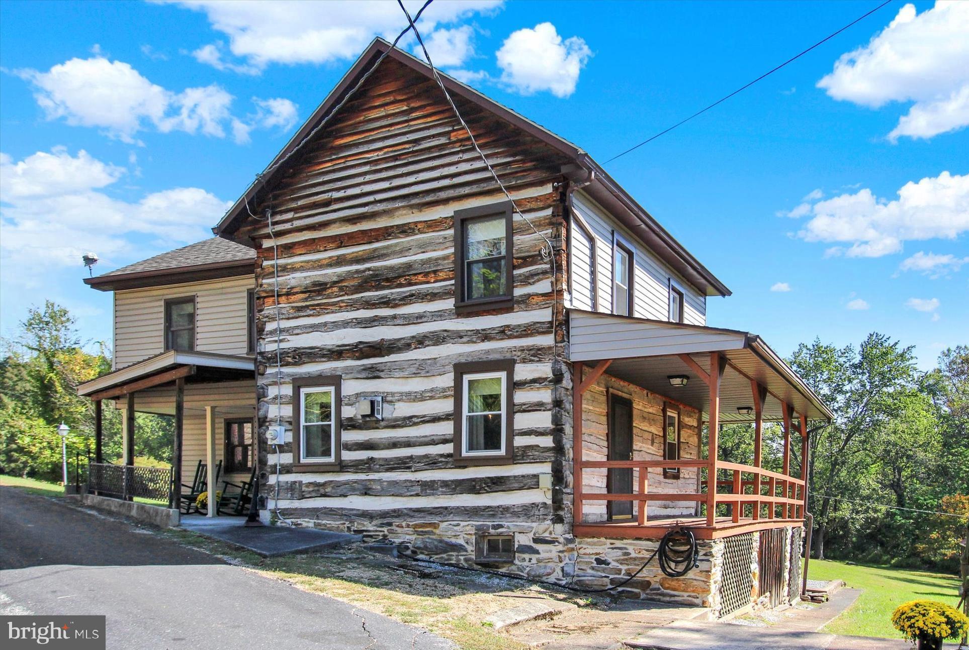Discover a one-of-a-kind trout fisherman’s paradise in Adams County, Pennsylvania … just miles from Michaux State Forest, the Appalachian Trail, and historic Gettysburg! This charming 1880s two-story log home offers 1,770 square feet of character and comfort with 4 bedrooms and 1.5  bathrooms. Relax on the inviting covered front porch or the side wrap-around porch overlooking the tranquil setting.  Step inside to experience the original log construction showcased in the 20x16 great room/log room, featuring lath and log walls, exposed beam ceilings, a propane wood stove, and wide-plank wood floors. The remodeled country kitchen blends rustic charm with modern updates, and wood floors are hidden beneath the carpeting throughout much of the home. The property includes replacement tilt-in windows, oil hot-water baseboard heat, and generous attic and basement storage. Outside, a collection of outbuildings offers endless possibilities … workshop, garden shed, wood shed, or art studio. The highlight is the fabulous 1.5-story summer kitchen, ideal as a guesthouse, playroom, or creative retreat. The expansive lawn leads to a meandering path to recently cleared stream bed and a once-very active trout stream, creating a peaceful haven for outdoor enthusiasts.  Whether you’re looking for a full-time residence, a weekend getaway, or an Airbnb investment, this property invites you to relax, explore, and enjoy the serenity of nature. Come see all the possibilities this historic log home has to offer!